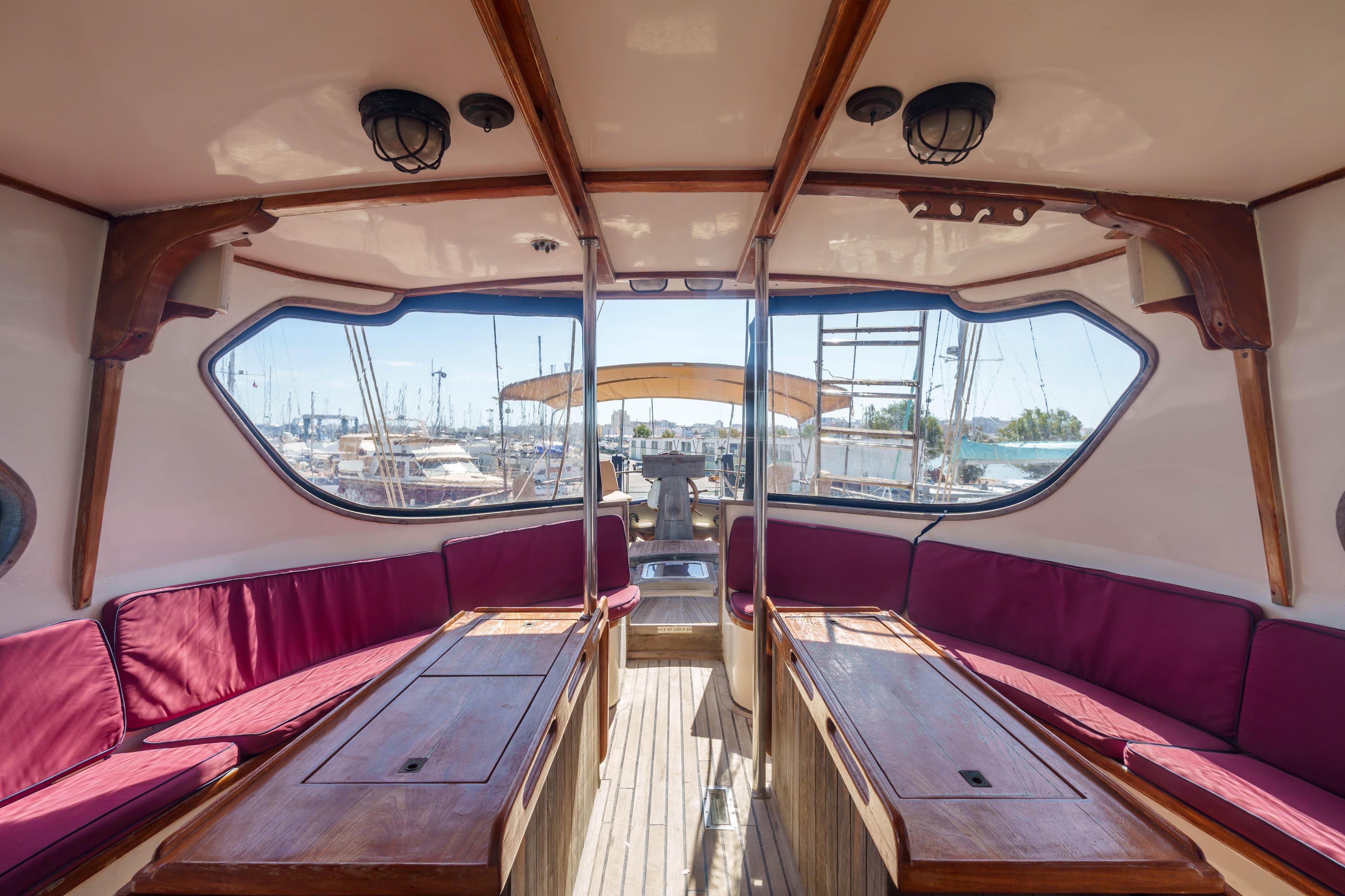 Interior of 1983 Cavalier Cavalier 92 yacht with red seating and wooden accents.