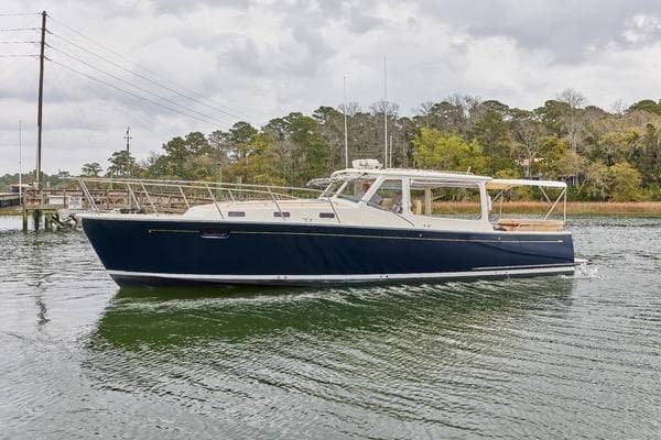 2018 MJM 40z yacht cruising on a calm river under cloudy skies.