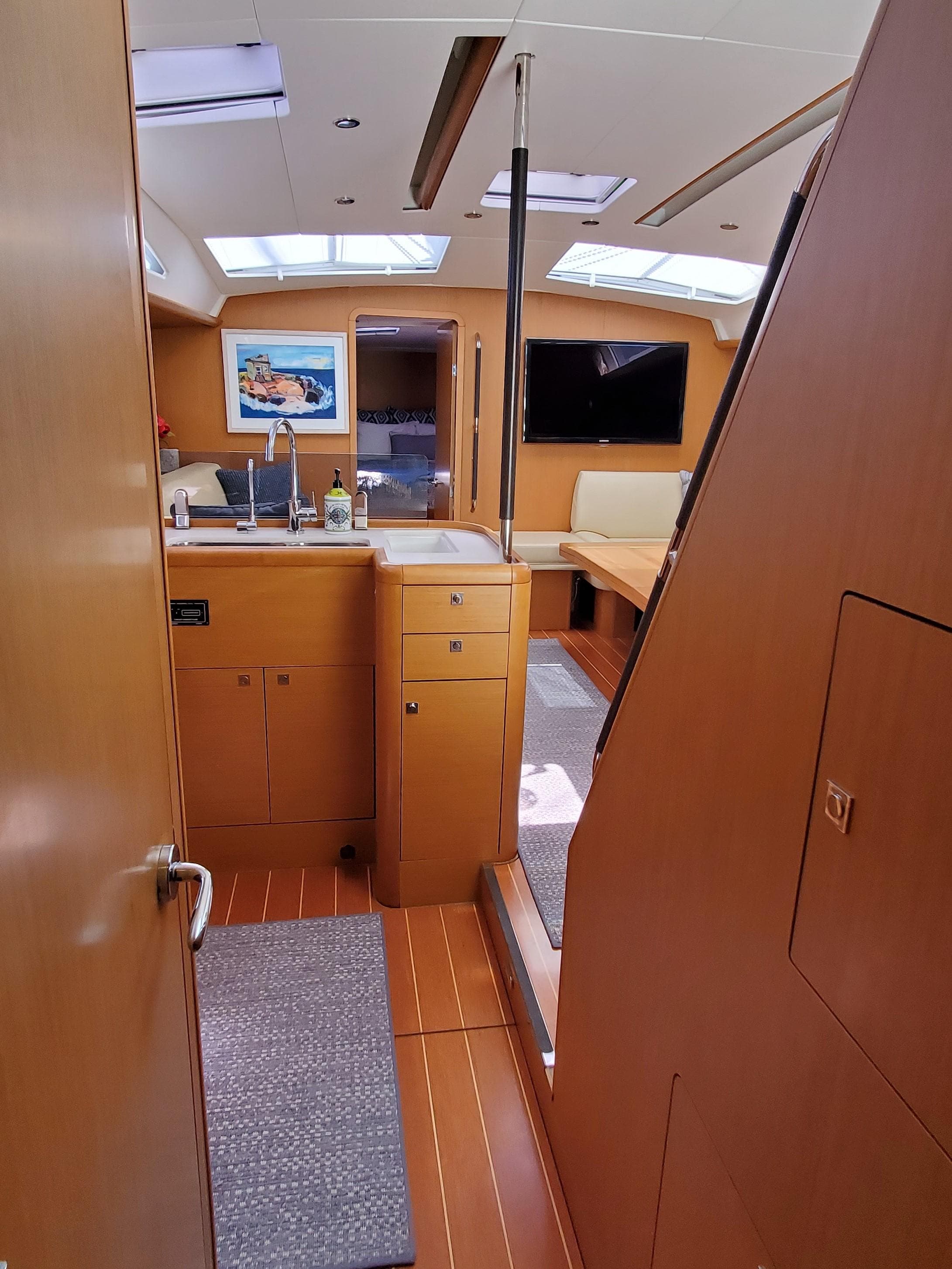 Interior of 2012 Jeanneau 53 sailboat with modern wood finish and skylights.