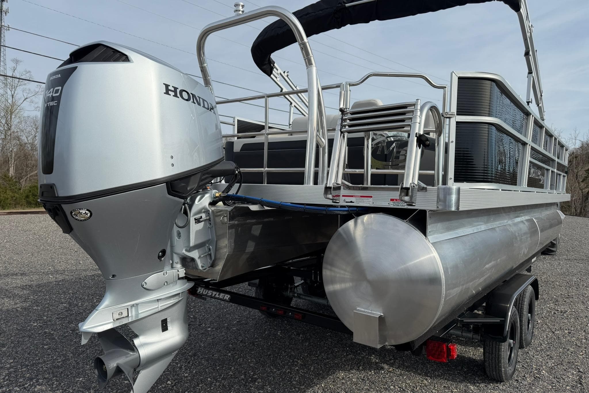 2026 Montego Bay 140HP pontoon boat with Honda outboard motor on trailer.