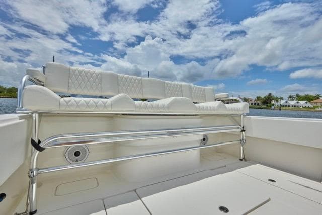 Invincible 36 boat interior, 2015 model, featuring white cushioned seating under a blue sky.