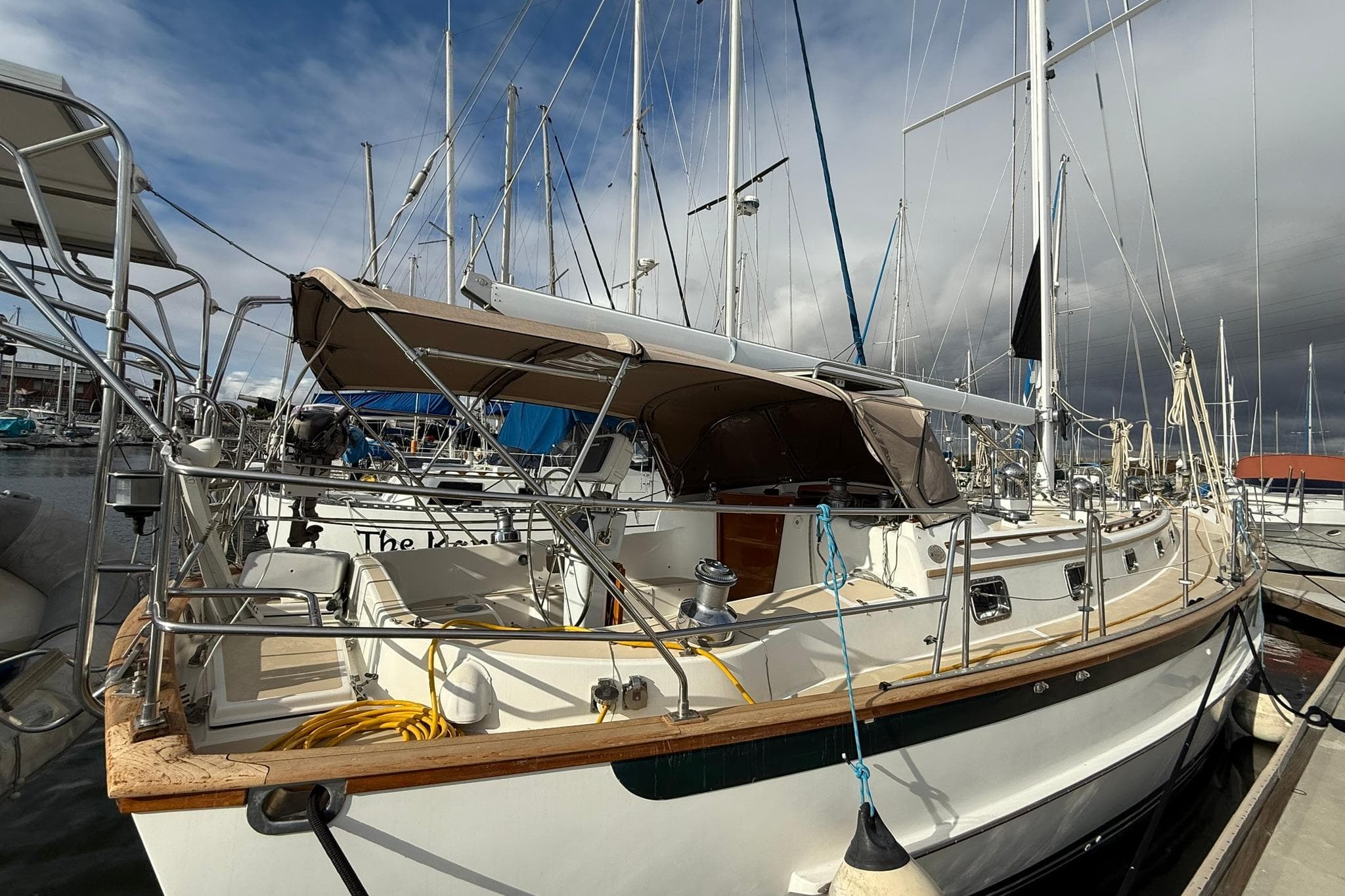 Cabo Rico Cutter 45 sailboat, 2000 model, docked at marina under cloudy sky.