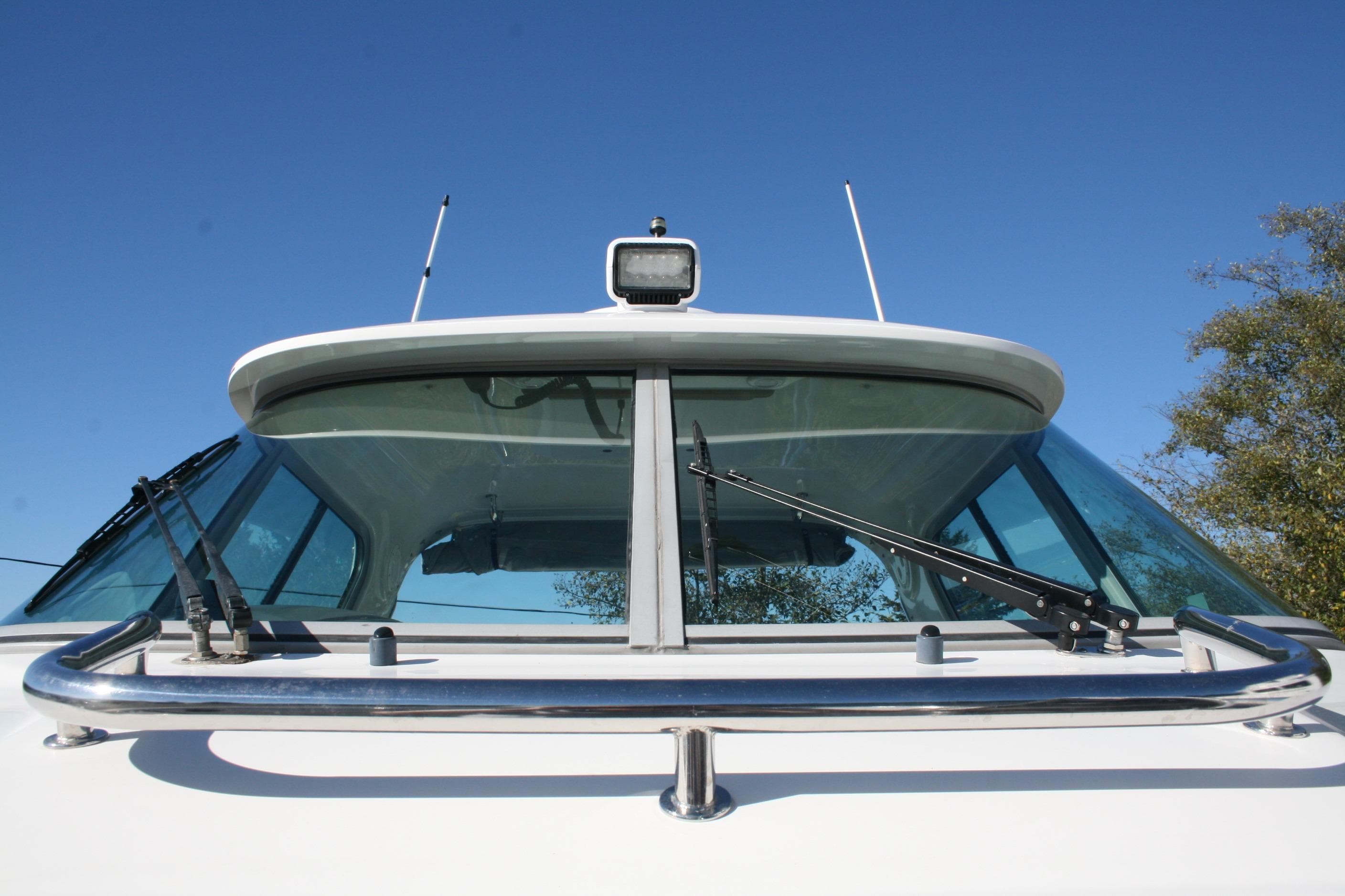 Front view of 2012 Protector Targa 30 boat with clear blue sky background.
