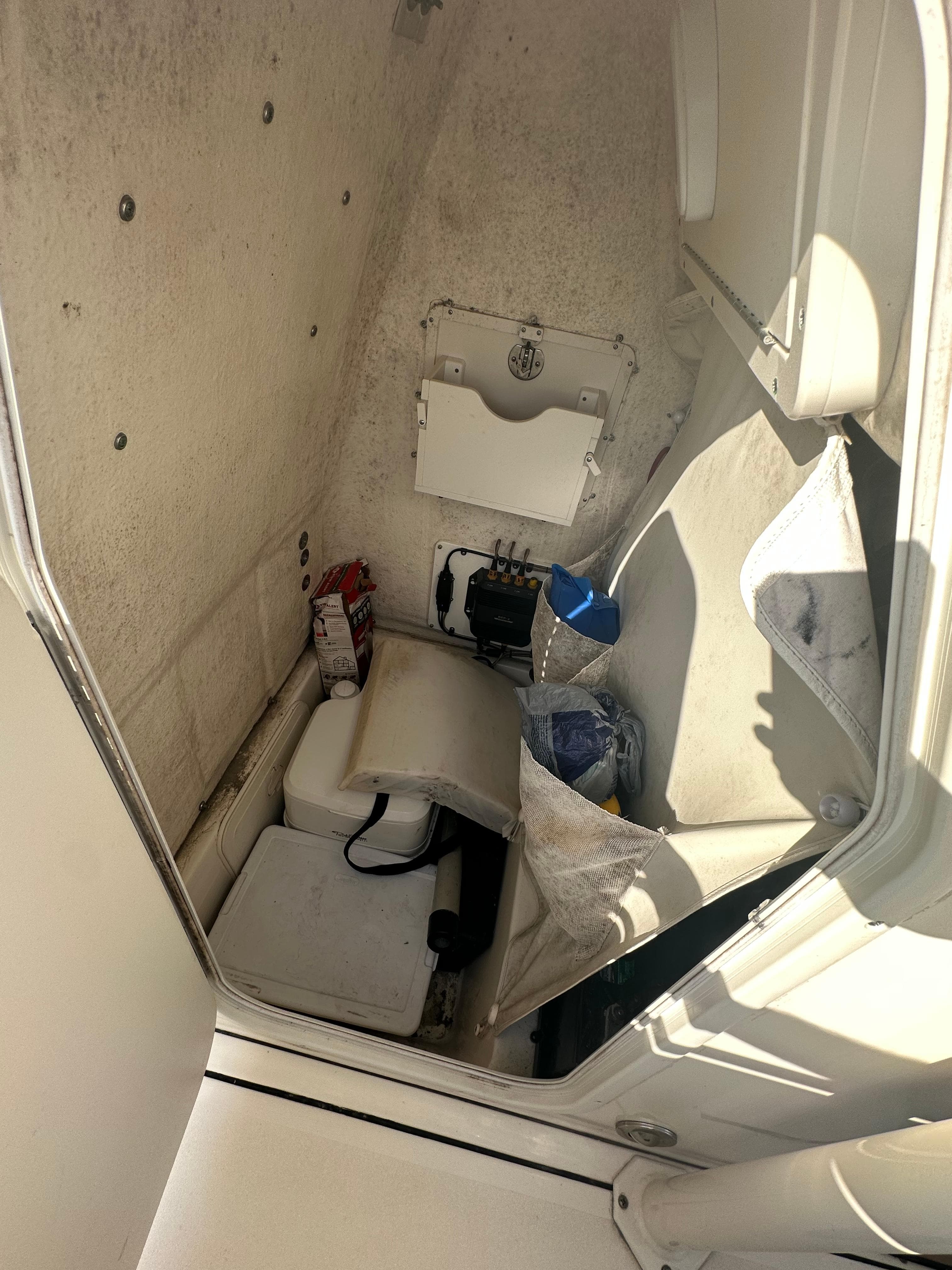 Interior storage compartment of 2018 Key West 244 CC boat, showing various items.