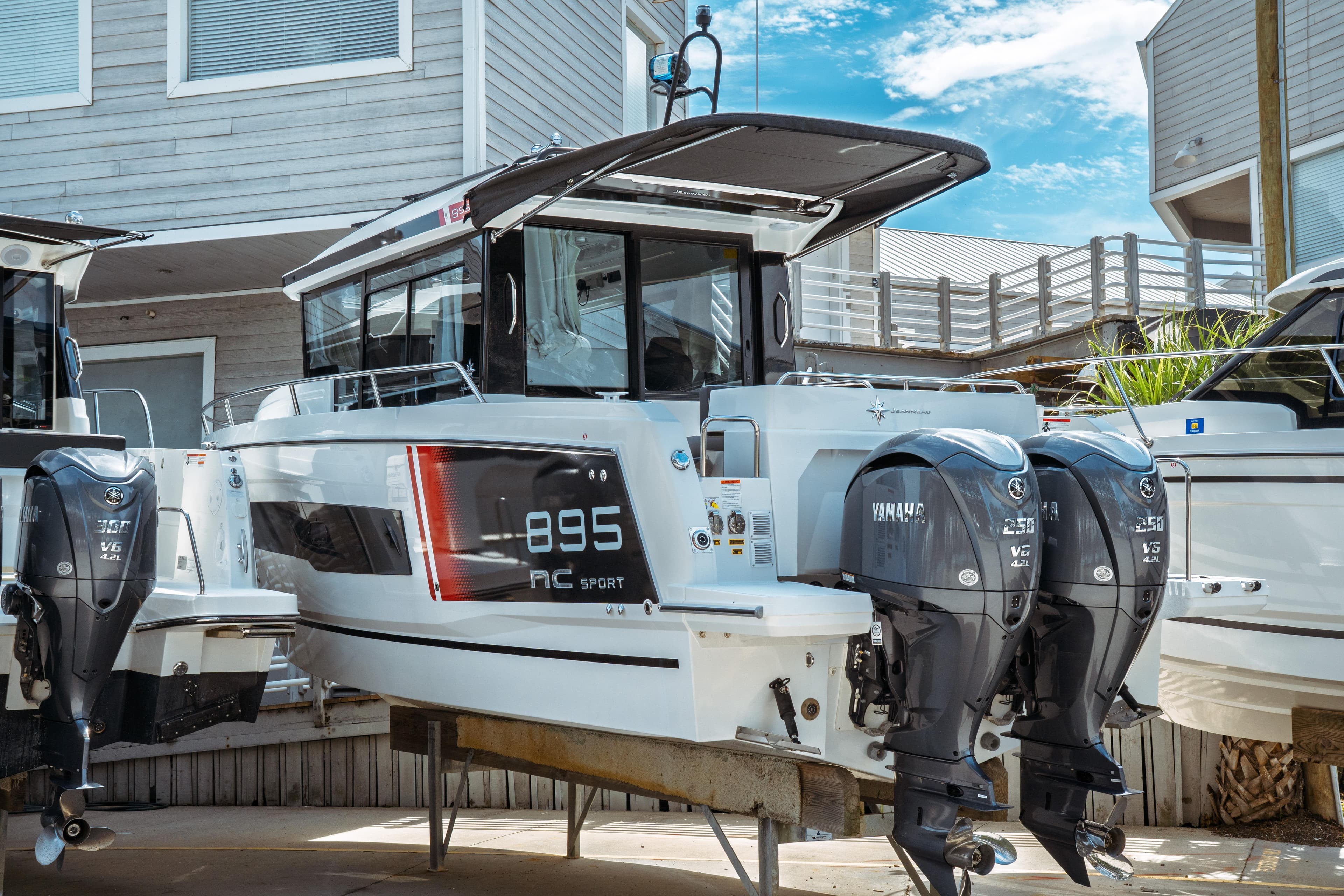 2025 Jeanneau NC 895 Sport Series 2 boat with twin Yamaha engines, docked outdoors.