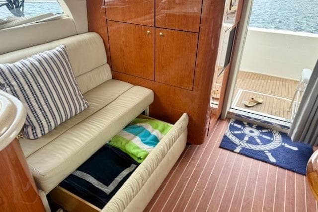 Interior of 2001 Sea Ray 540 Cockpit Motor Yacht with sofa, storage, and nautical decor.