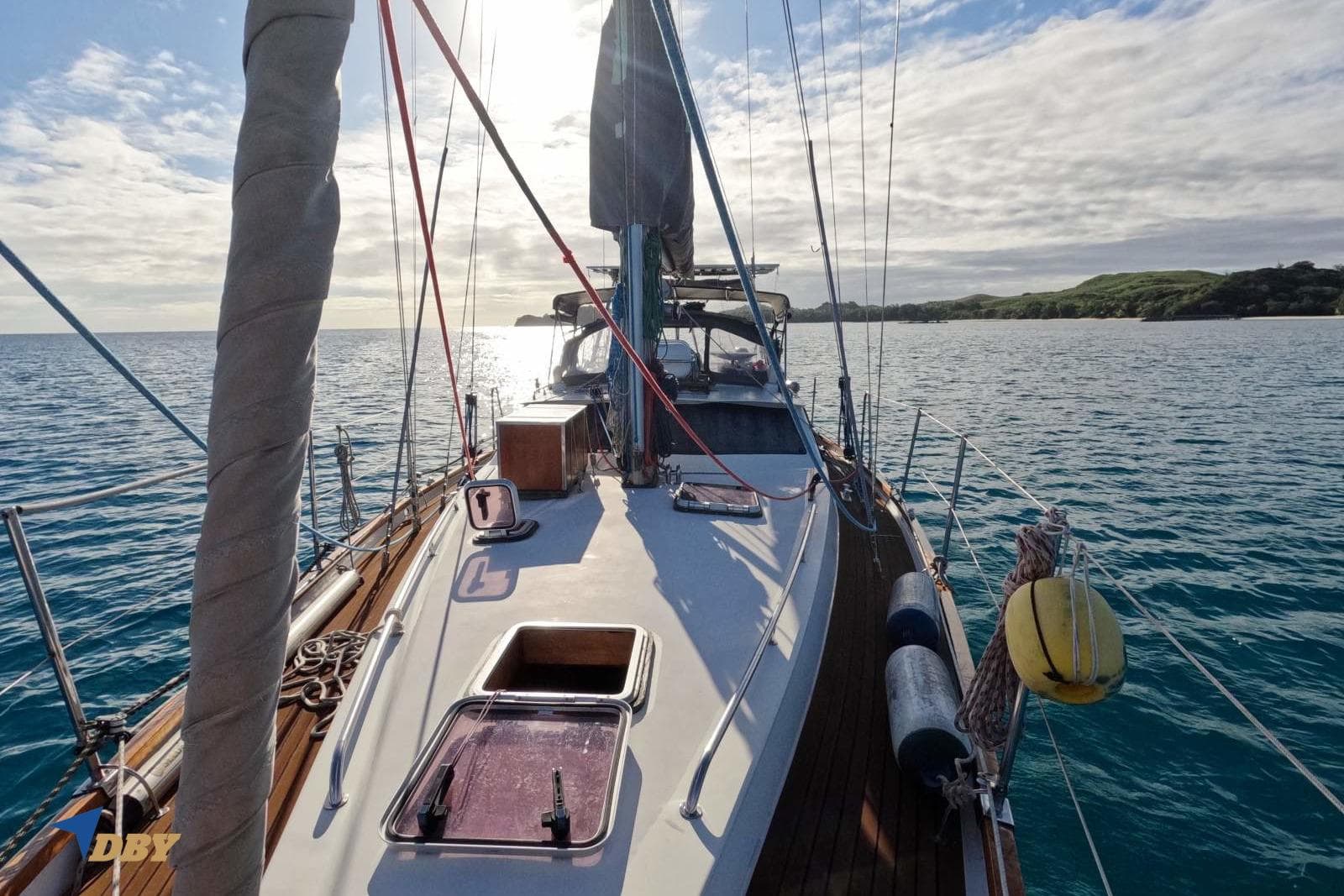 Sailing yacht Dudley Dix 43, 2006 model, cruising on calm waters under a partly cloudy sky.