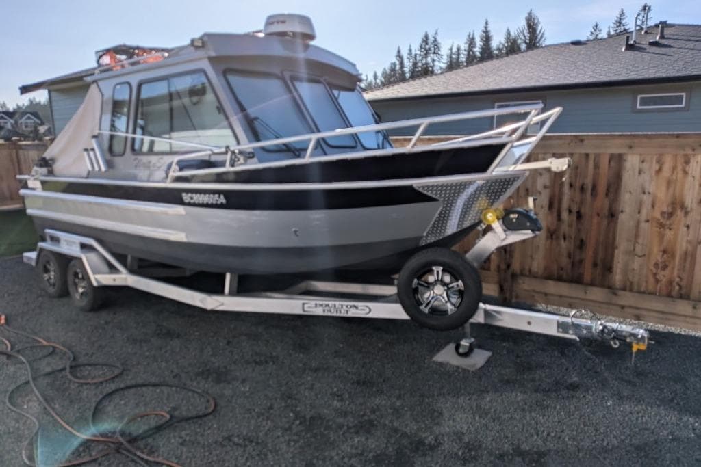 2023 Boulton VOYAGER PRO boat on trailer, parked in a residential area.