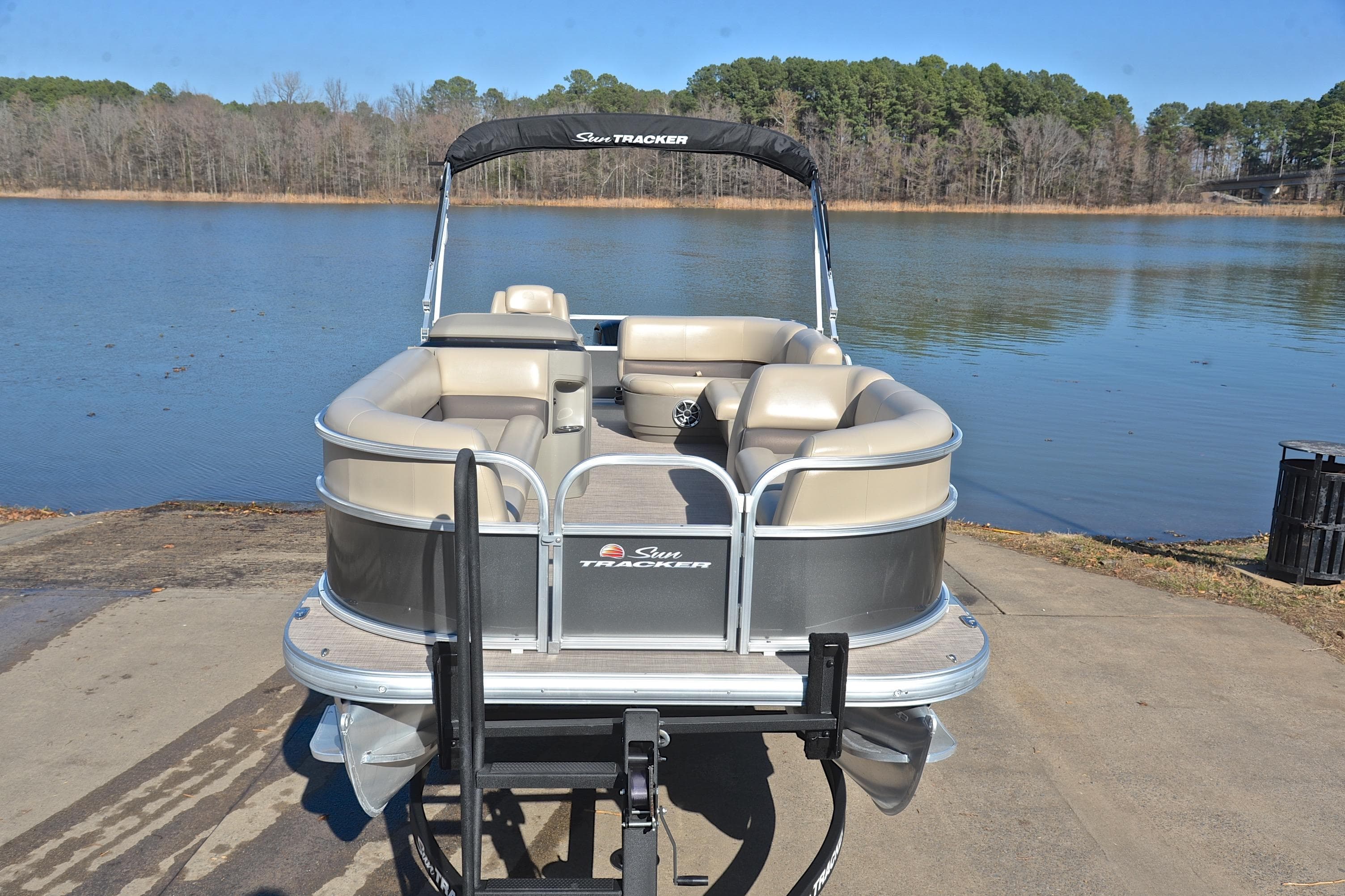 2025 Sun Tracker Party Barge 18 DLX pontoon boat on a lake ramp.