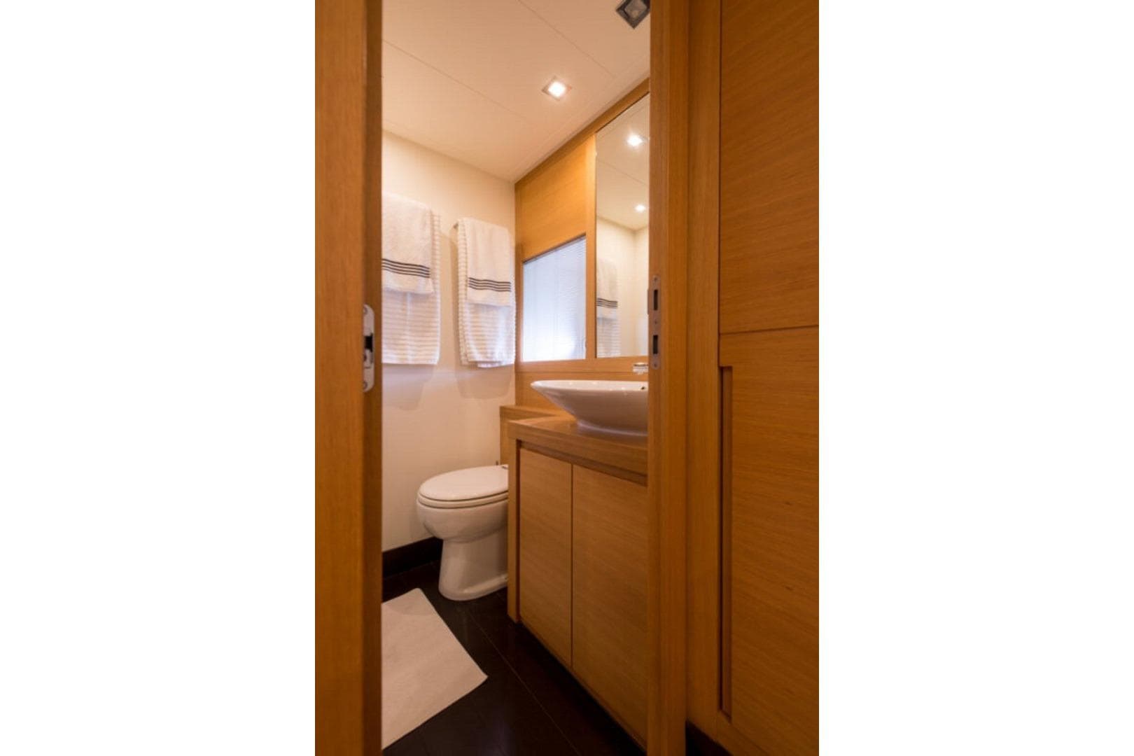 Luxurious bathroom interior of 2008 Pershing 64' yacht with modern wood finishes.