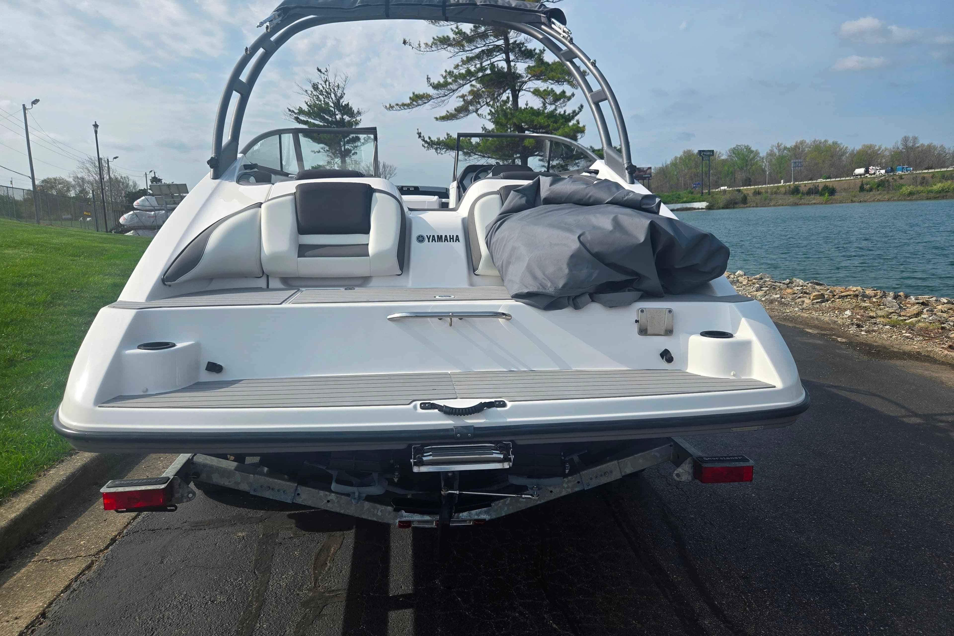 2022 Yamaha AR210 boat on trailer by a lakeside, ready for launch.