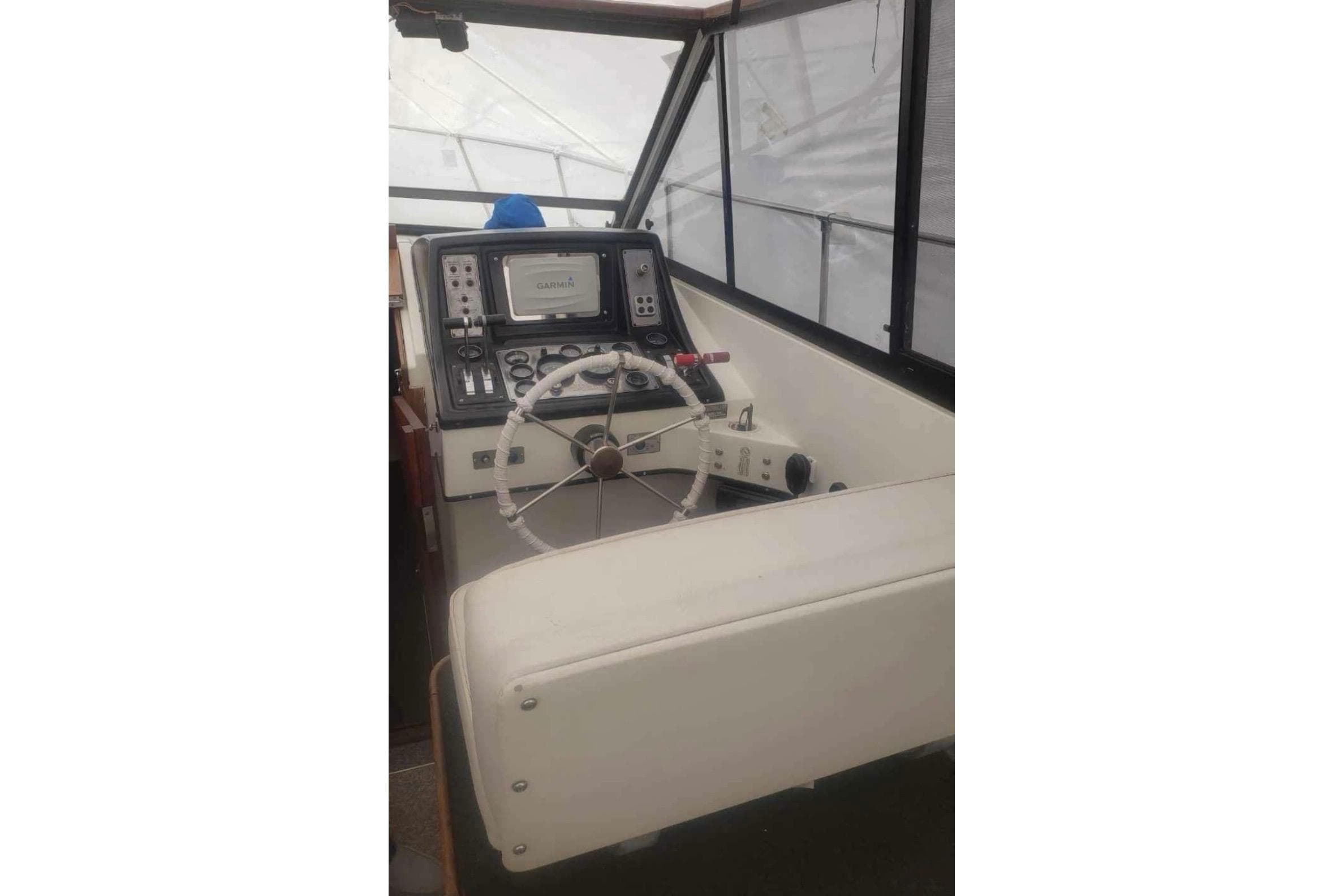 1985 Carver 28 Riviera boat helm with steering wheel and navigation equipment.