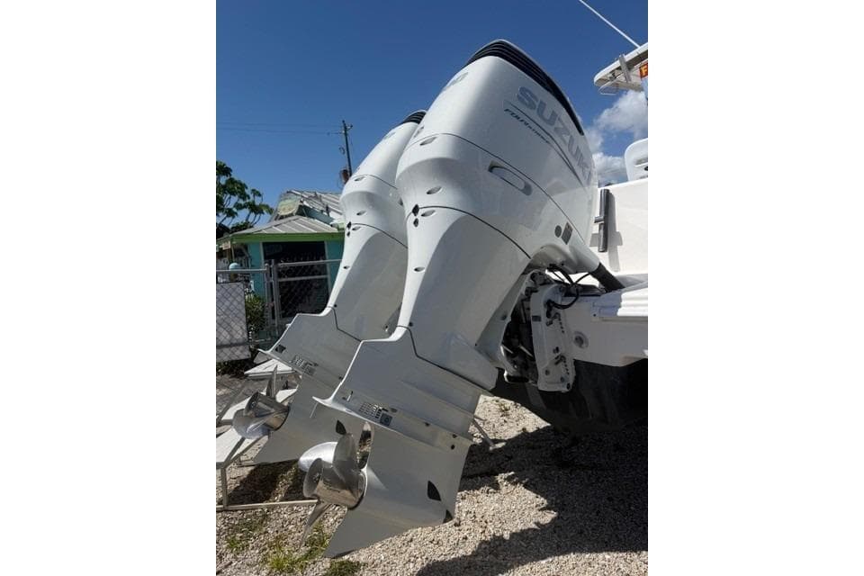 Twin Suzuki outboard motors on a 2005 PROLINE Super Sport boat, parked outdoors.