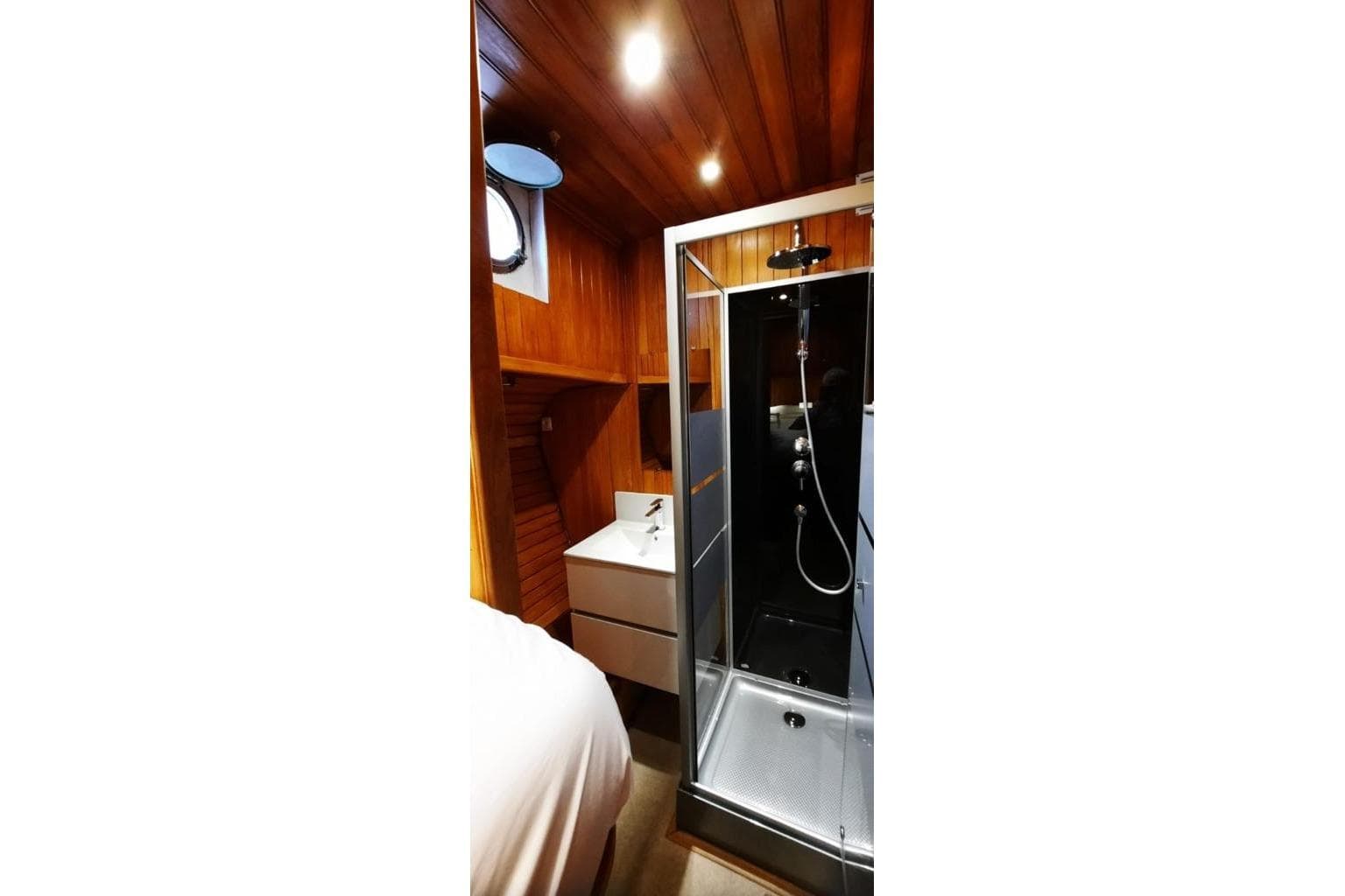 1978 Chantier de l’Esterel Vedette yacht bathroom with wooden interior and modern shower.