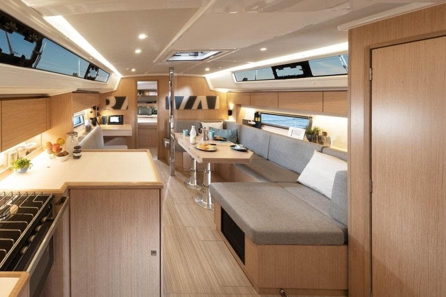 Modern interior of 2026 Bavaria C42 yacht with sleek kitchen and cozy seating area.