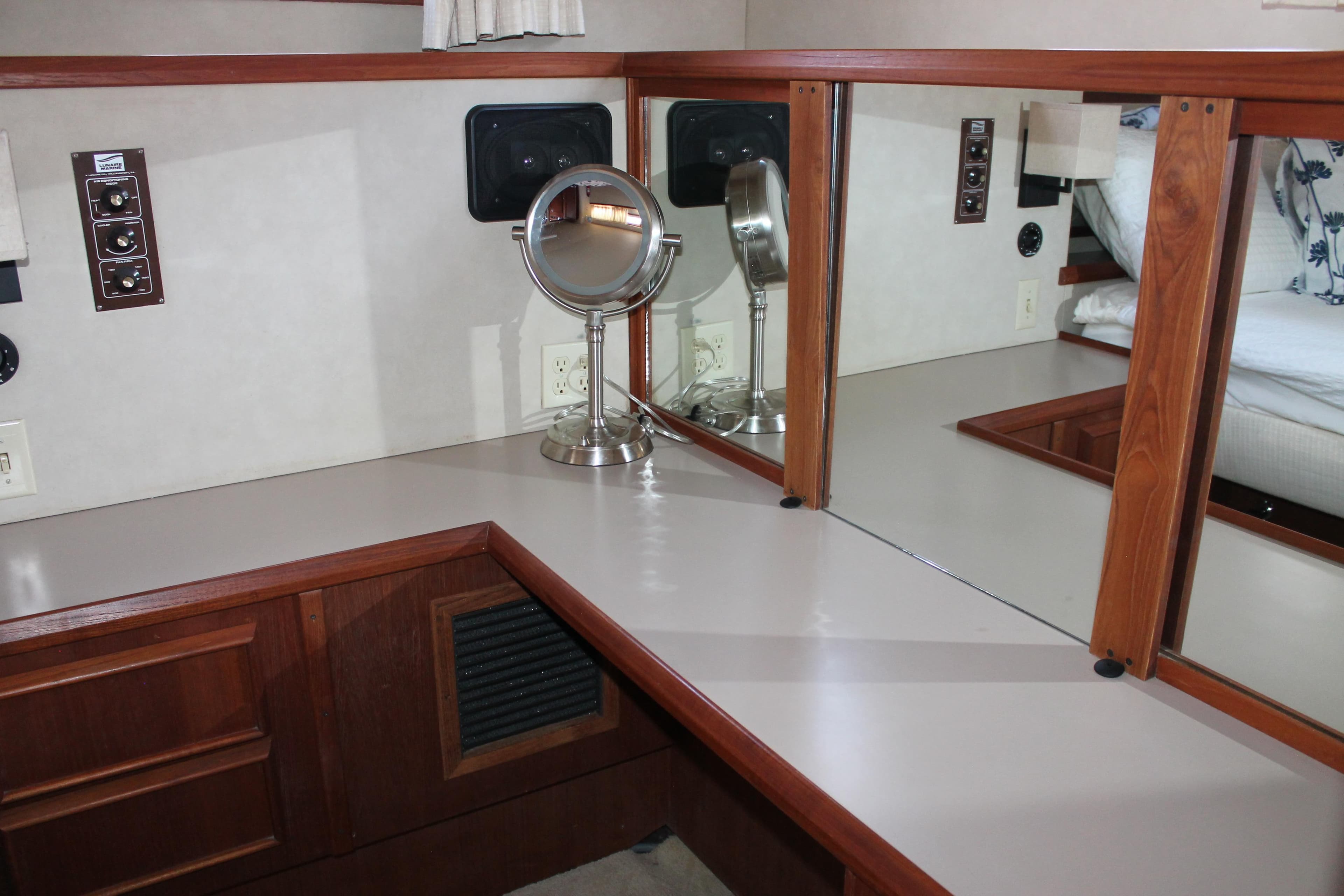 Interior of 1987 Chris-Craft 427 Catalina with vanity mirror and wooden cabinetry.
