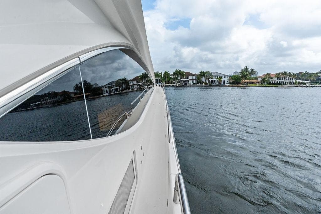 Sunseeker 88 Yacht 2012 cruising near waterfront homes under cloudy skies.