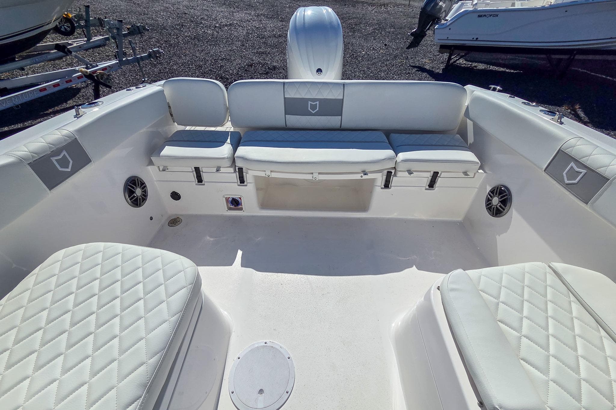 2026 Sea Fox 228 Traveler boat interior with white cushioned seating and speakers.