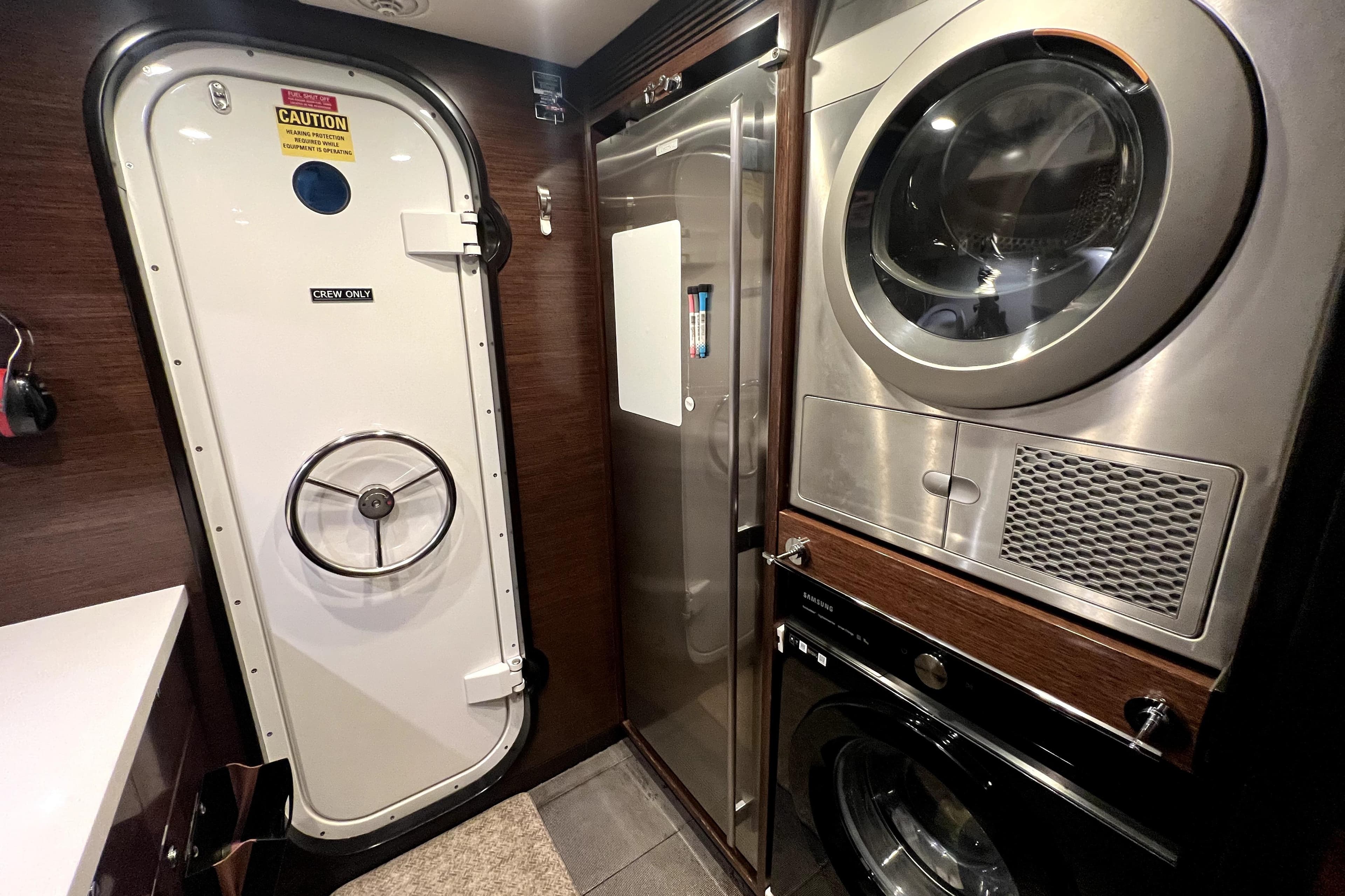 Laundry area in 2009 Nordhavn N78 yacht with washer, dryer, and crew-only door.