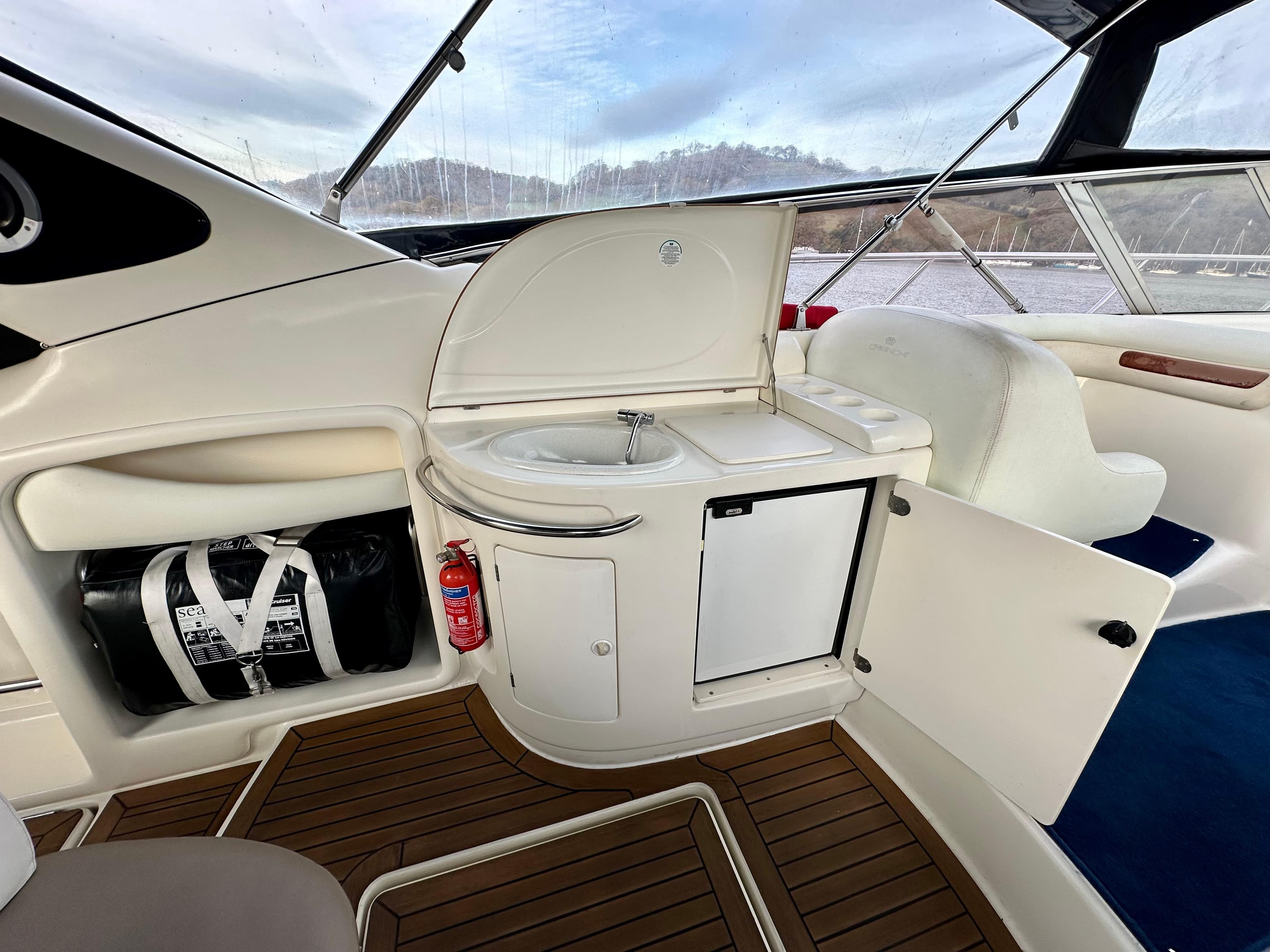 1999 Cranchi Endurance 39 yacht interior with sink, mini fridge, and wooden flooring.