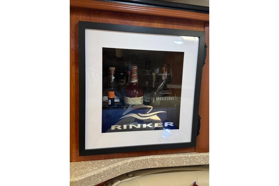 Framed Rinker logo with bottles inside a 2005 Rinker Fiesta Vee 320 boat interior.