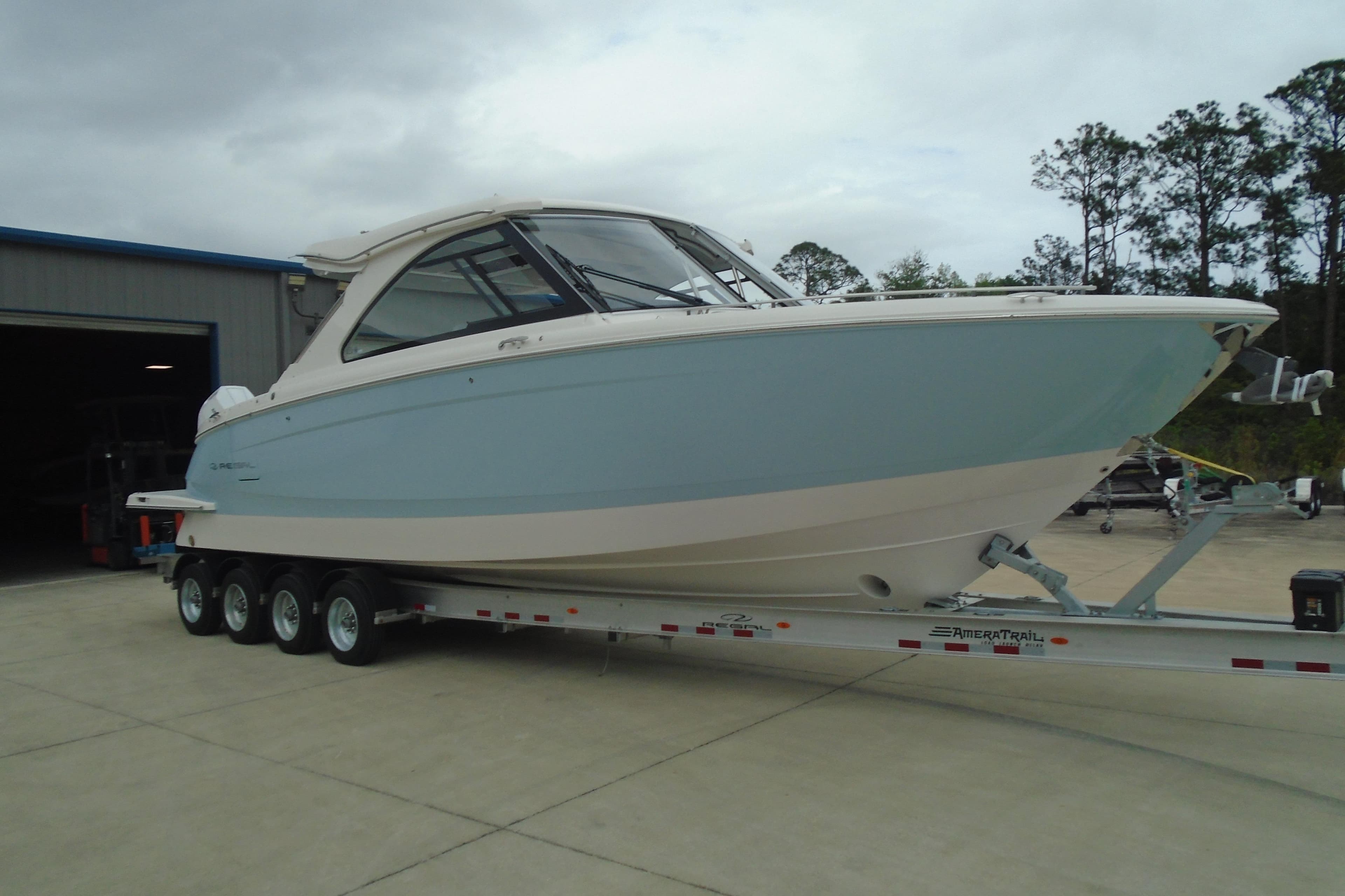 2026 Regal LX36 boat on trailer, parked outdoors near a building.