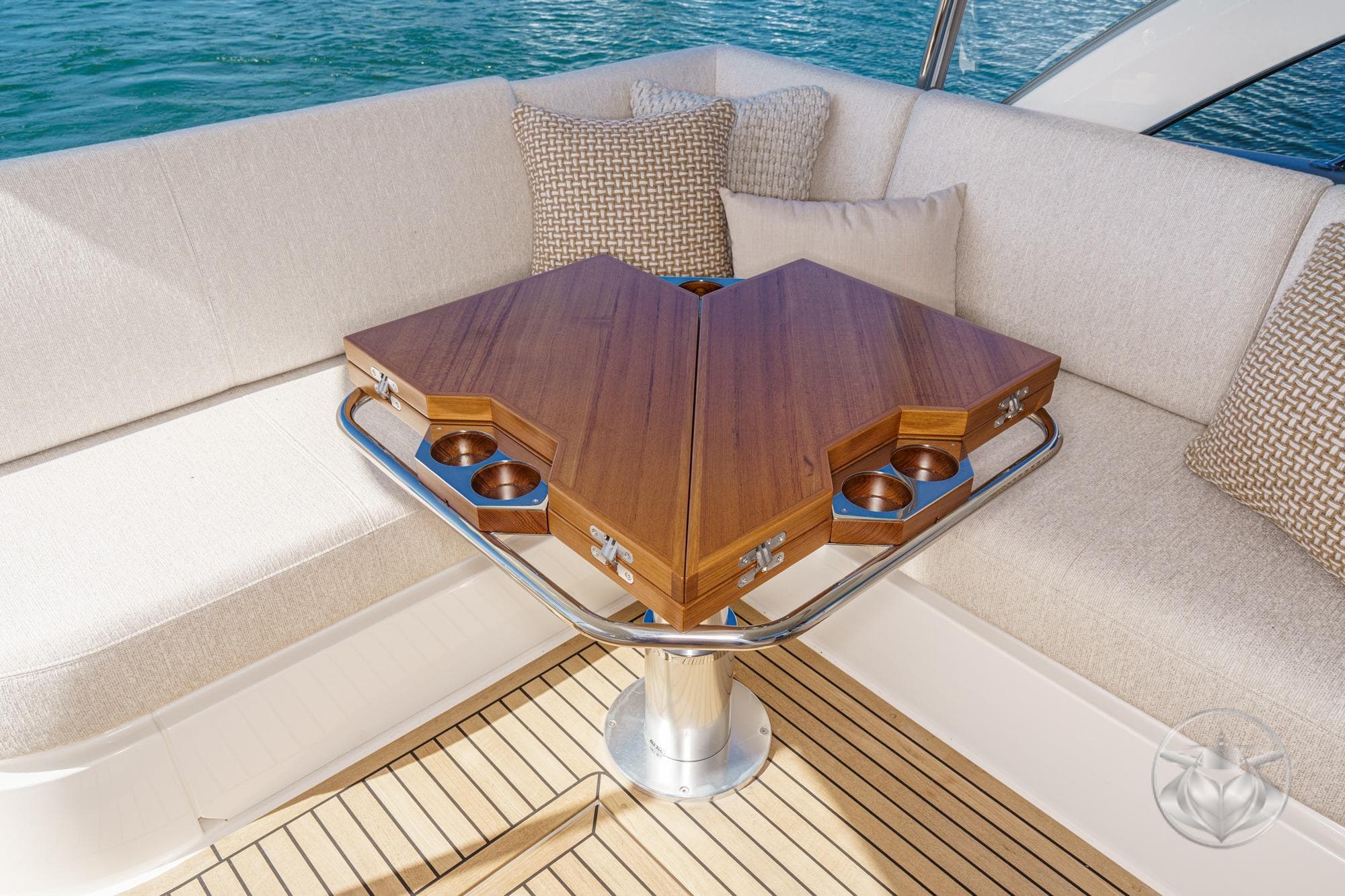 Luxurious seating area on 2026 Riviera 4300 Sport Express yacht with elegant wooden table.