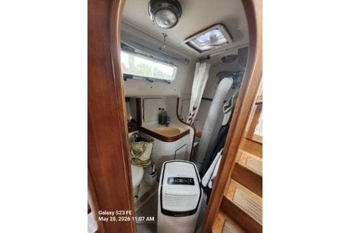 Interior of a 1995 Freedom 35 sailboat, featuring a compact bathroom with wooden accents.