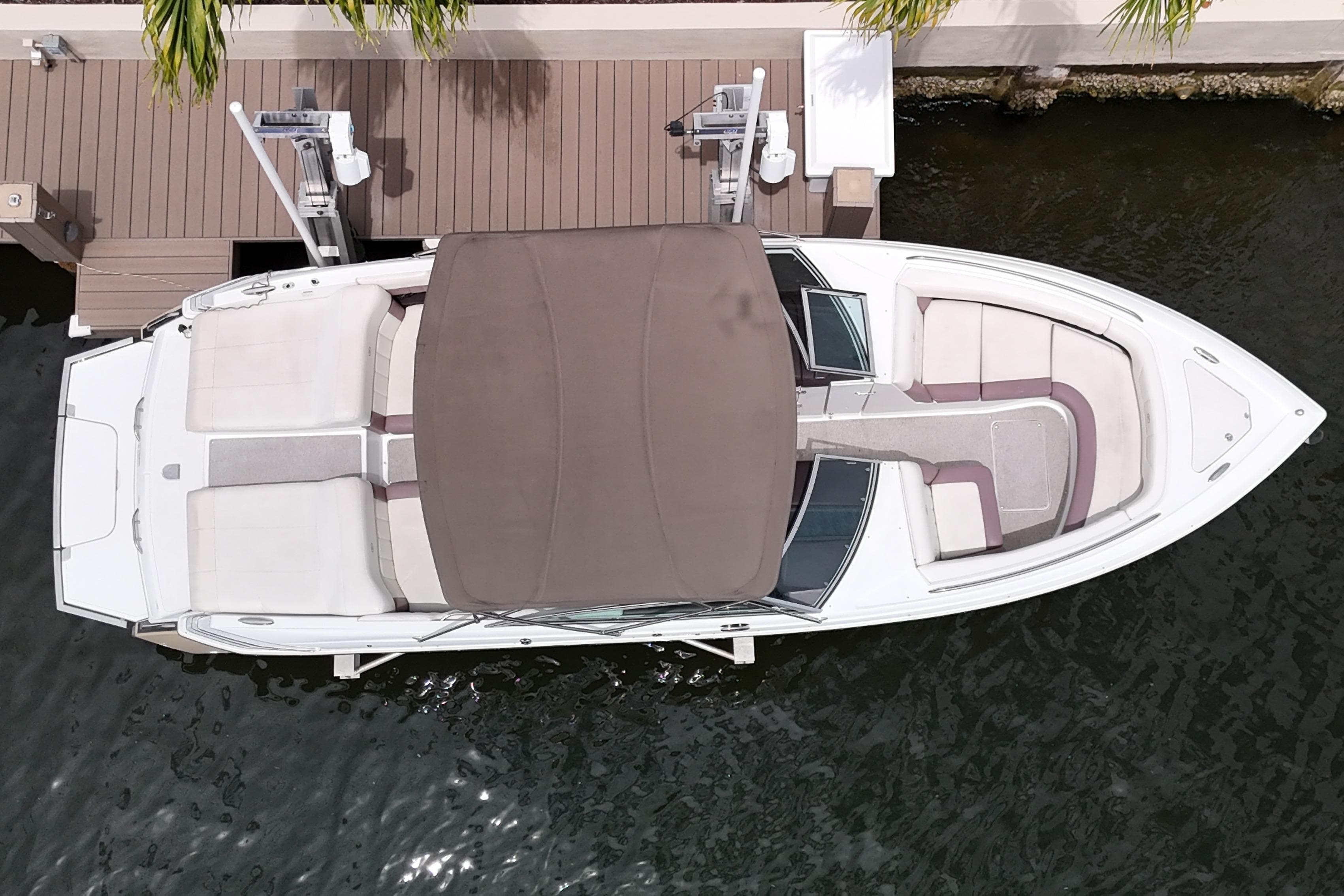 Overhead view of a 2013 Cobalt 296 boat docked by a wooden pier.
