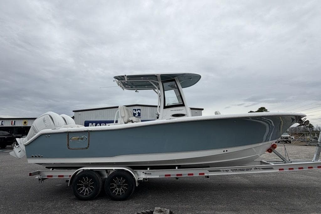 2026 Sea Hunt Ultra 265 SE boat on trailer, side view under cloudy sky.
