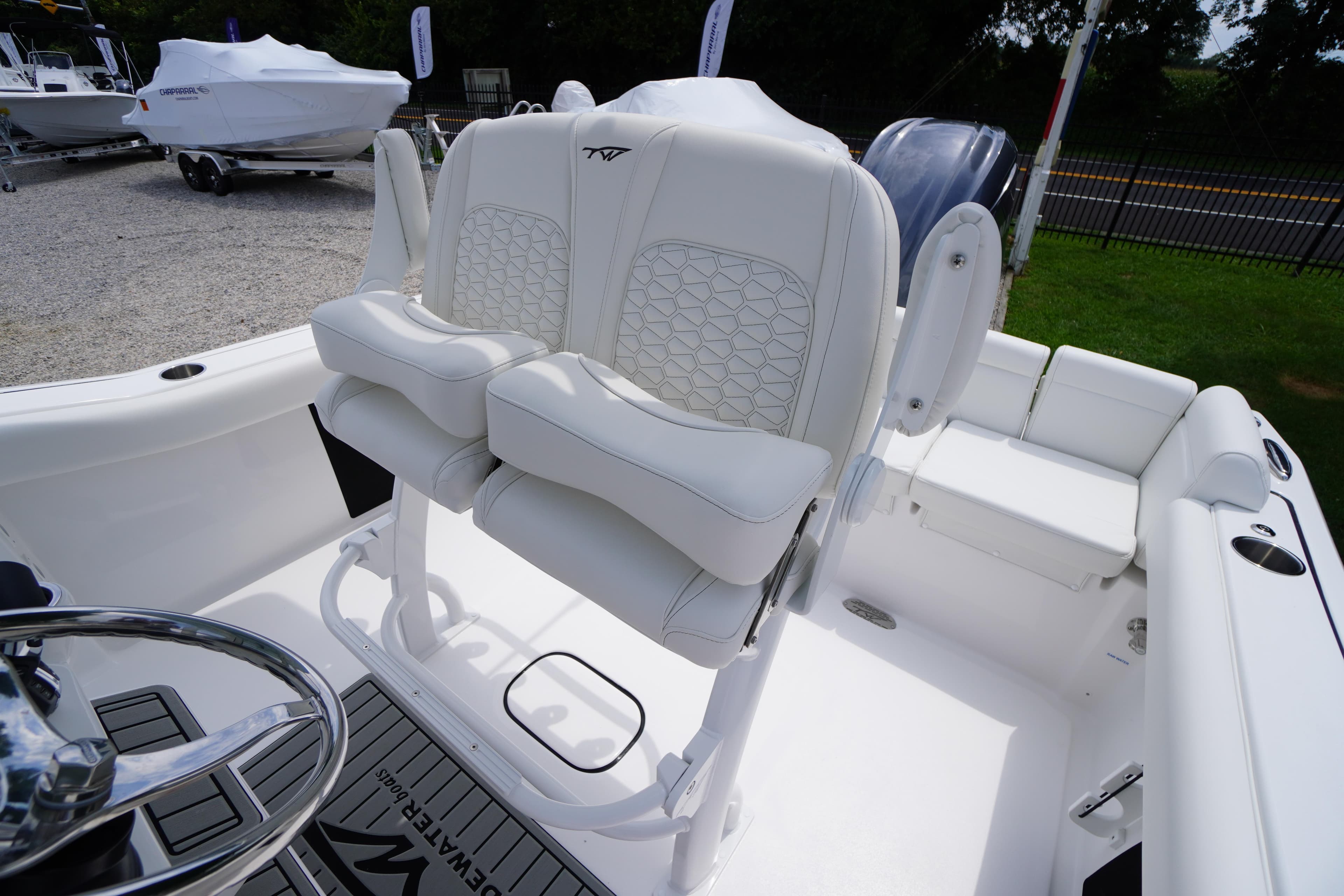 2026 Tidewater 232 SS boat interior with white cushioned seating and steering wheel.