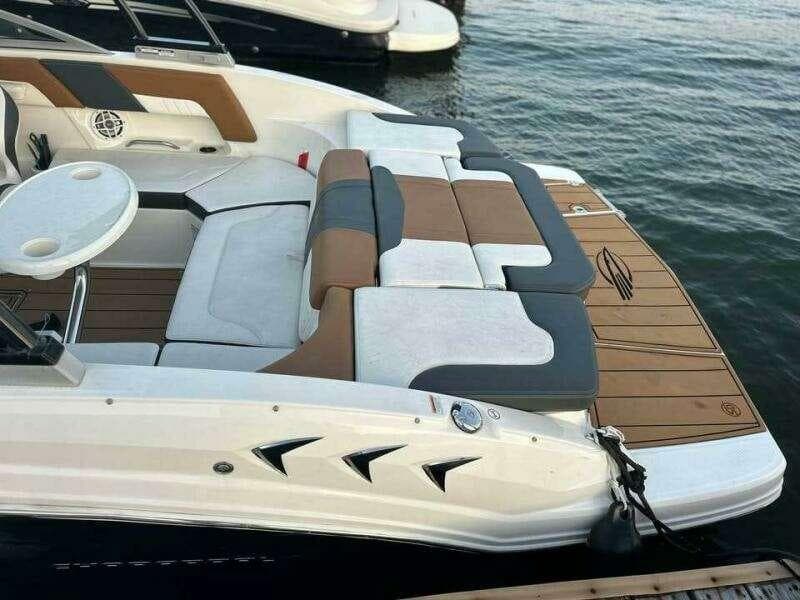 2023 Chaparral 230 SSi boat with stylish seating and swim platform on the water.