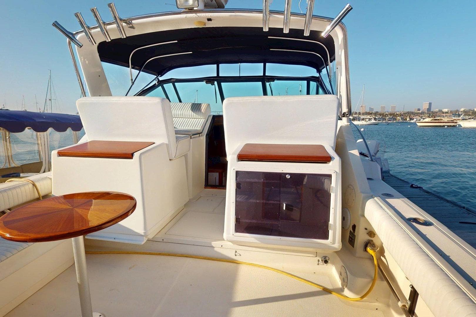 1989 Tiara 3300 Open yacht interior with seating and table, docked in a marina.