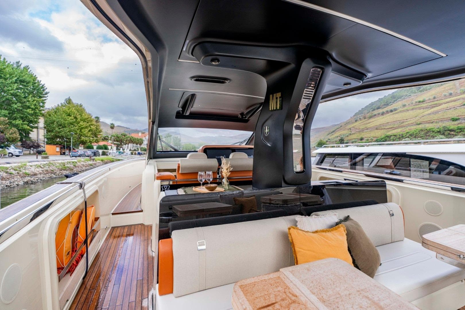 Luxurious 2022 Invictus TT460 yacht interior with elegant seating and scenic river view.