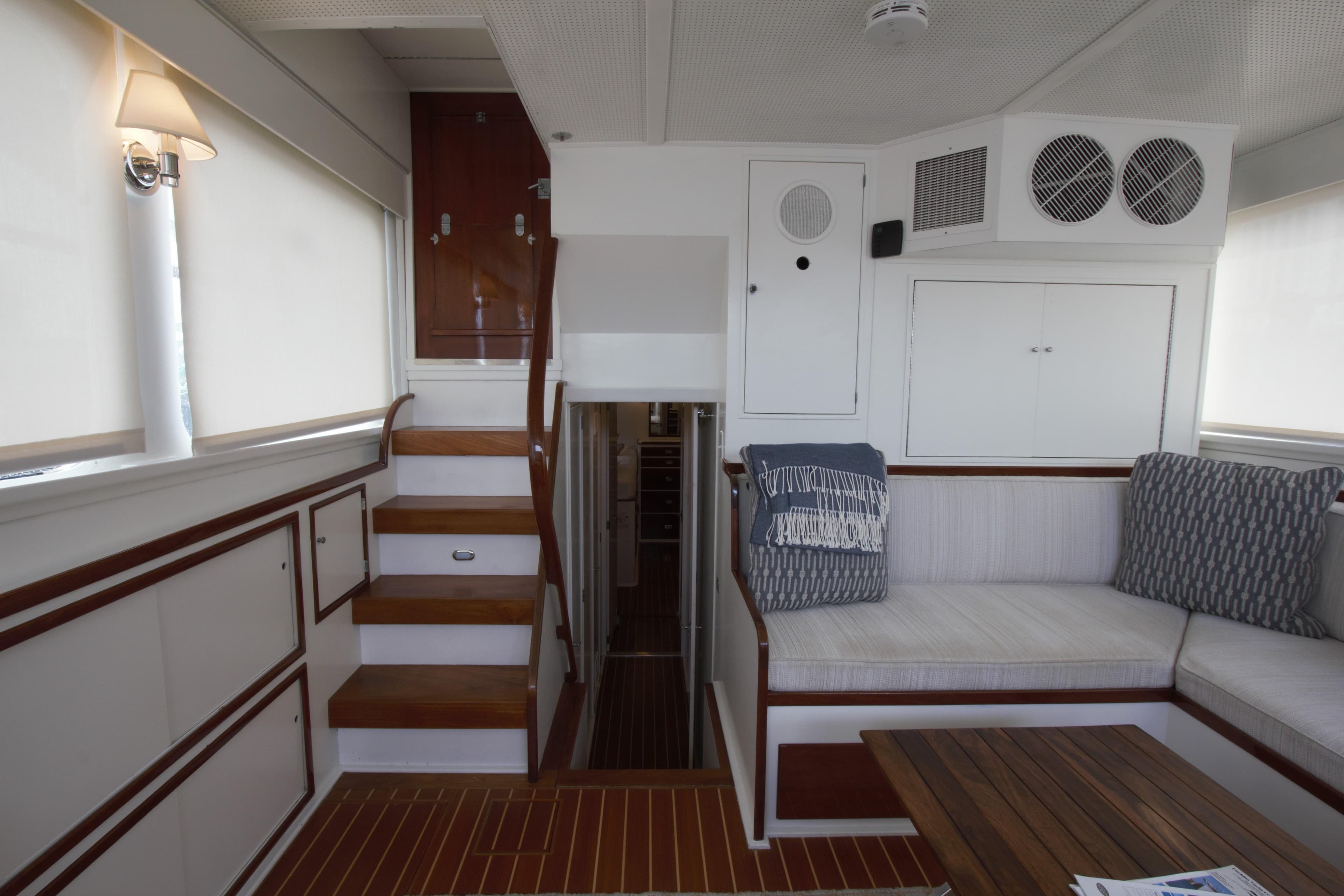 Interior of a 1963 Huckins Linwood yacht with wooden accents and cozy seating.