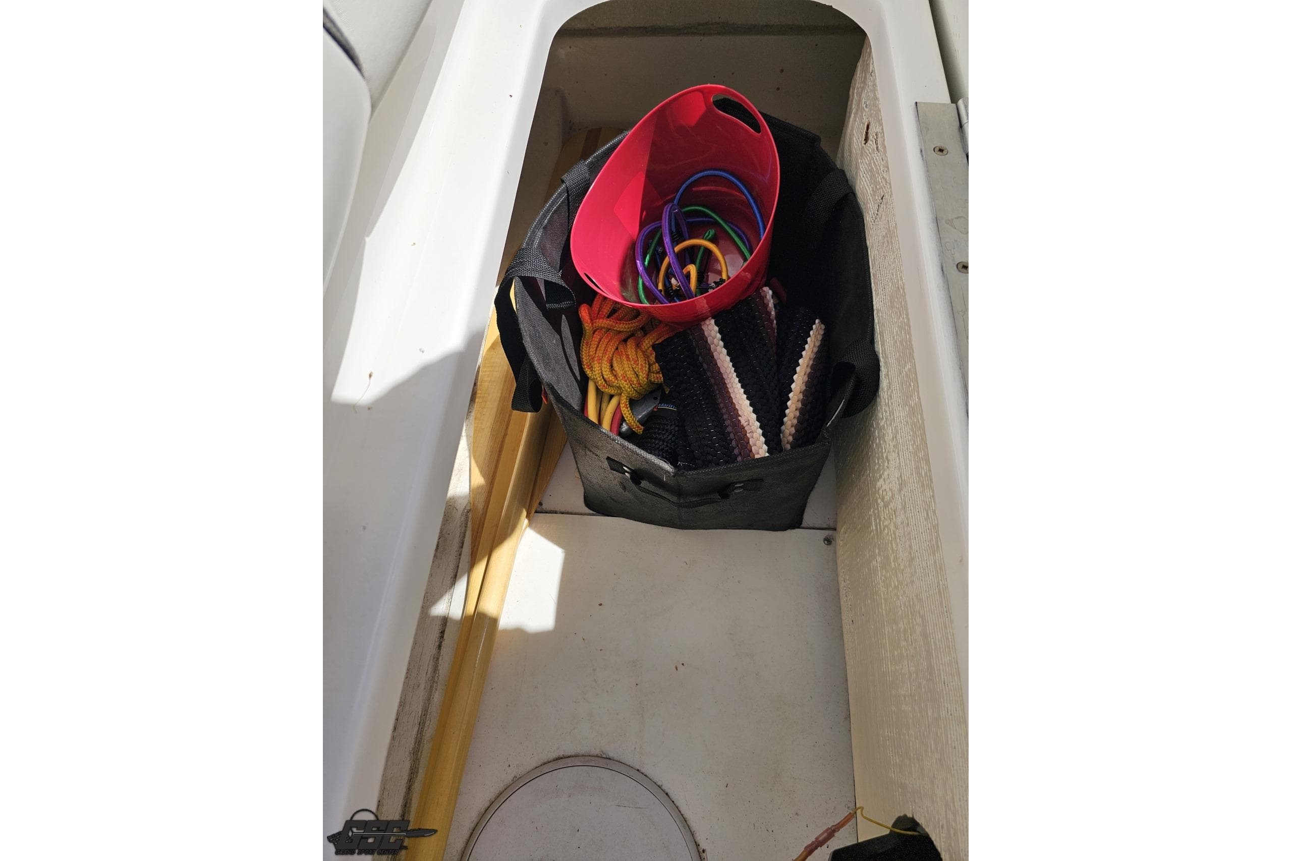 Storage compartment of a 2019 Baja 27 Outlaw boat with ropes and accessories.