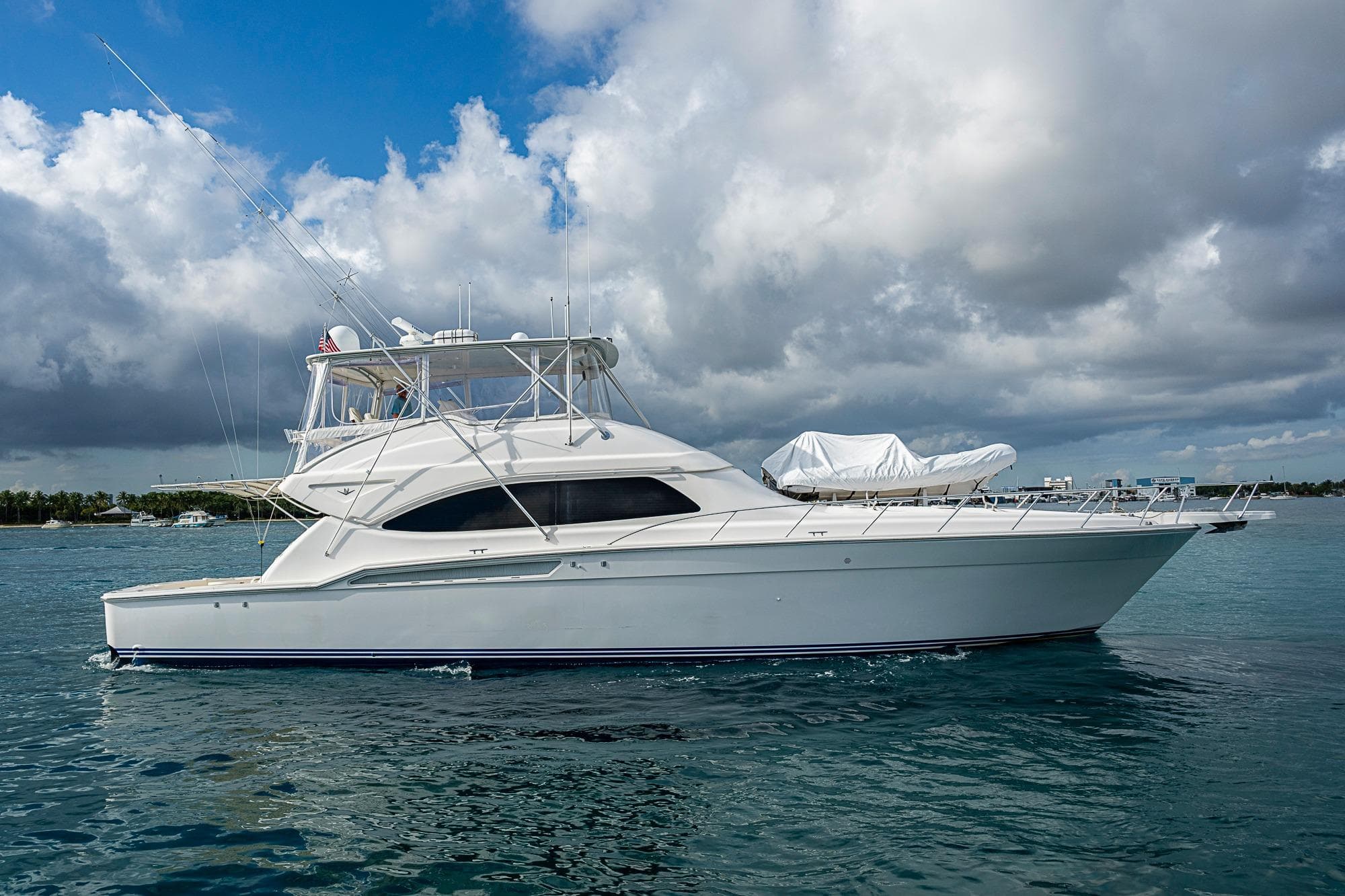 2006 Bertram 630 Convertible yacht on calm water under cloudy sky.