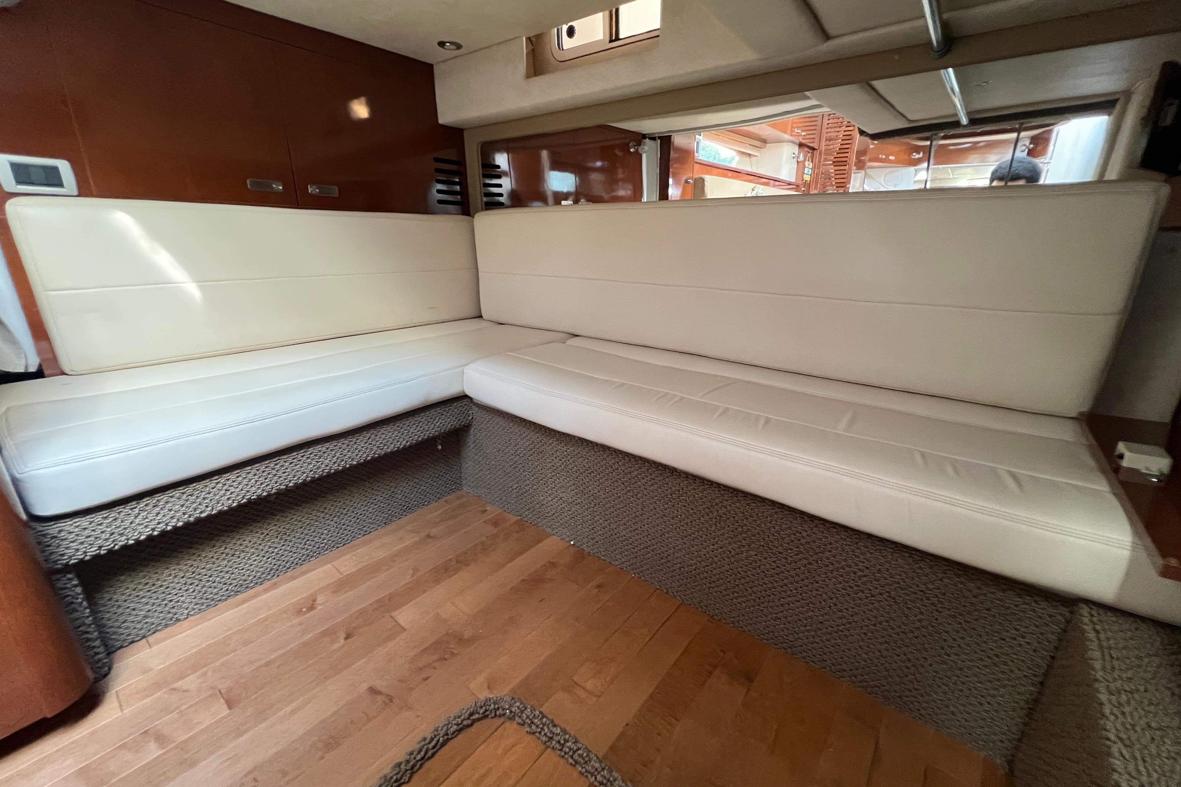 Interior of 2012 Sea Ray 370 Sundancer with beige seating and wooden flooring.