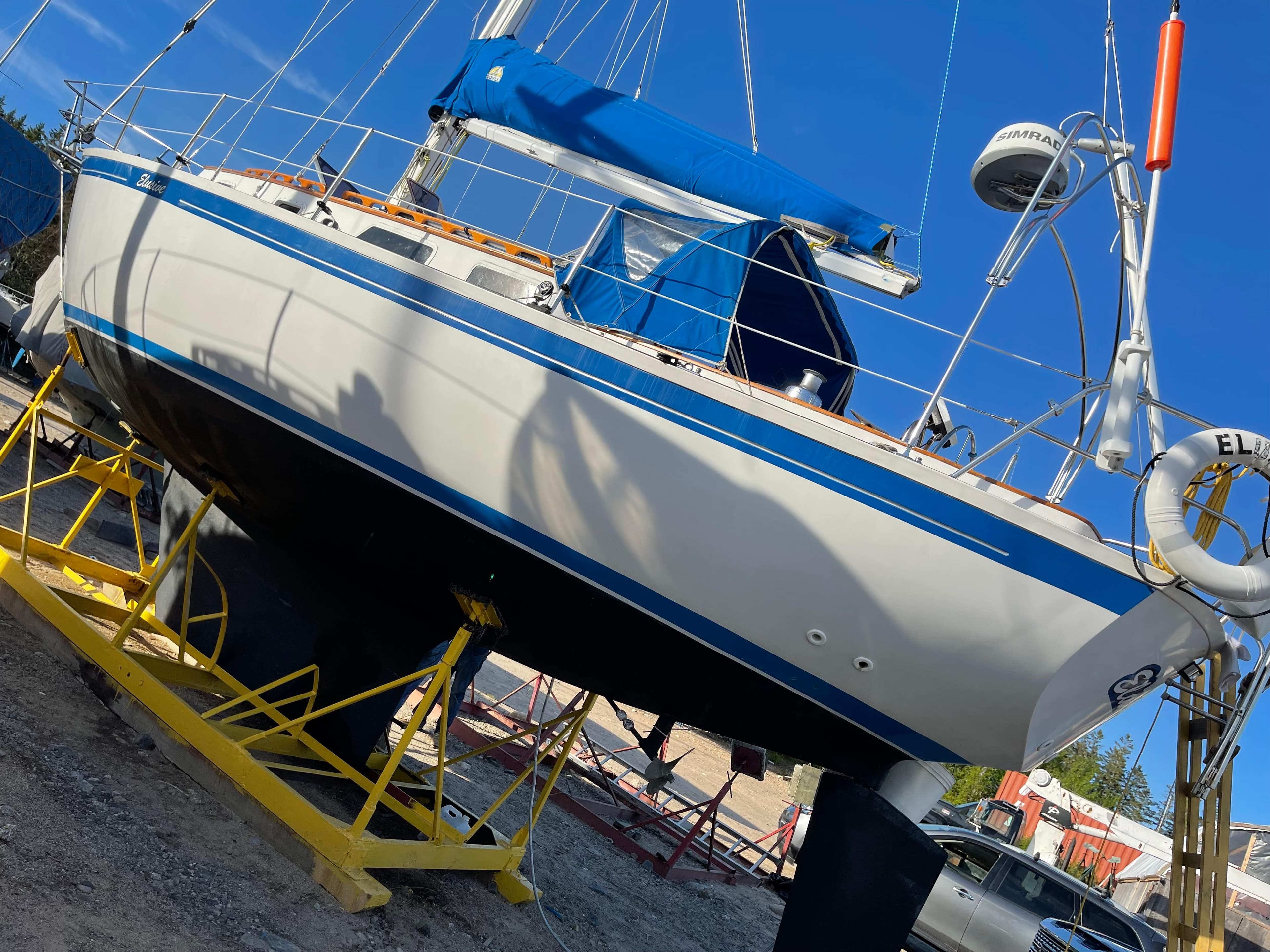1983 Aloha 32 sailboat on dry dock with blue accents and equipment.