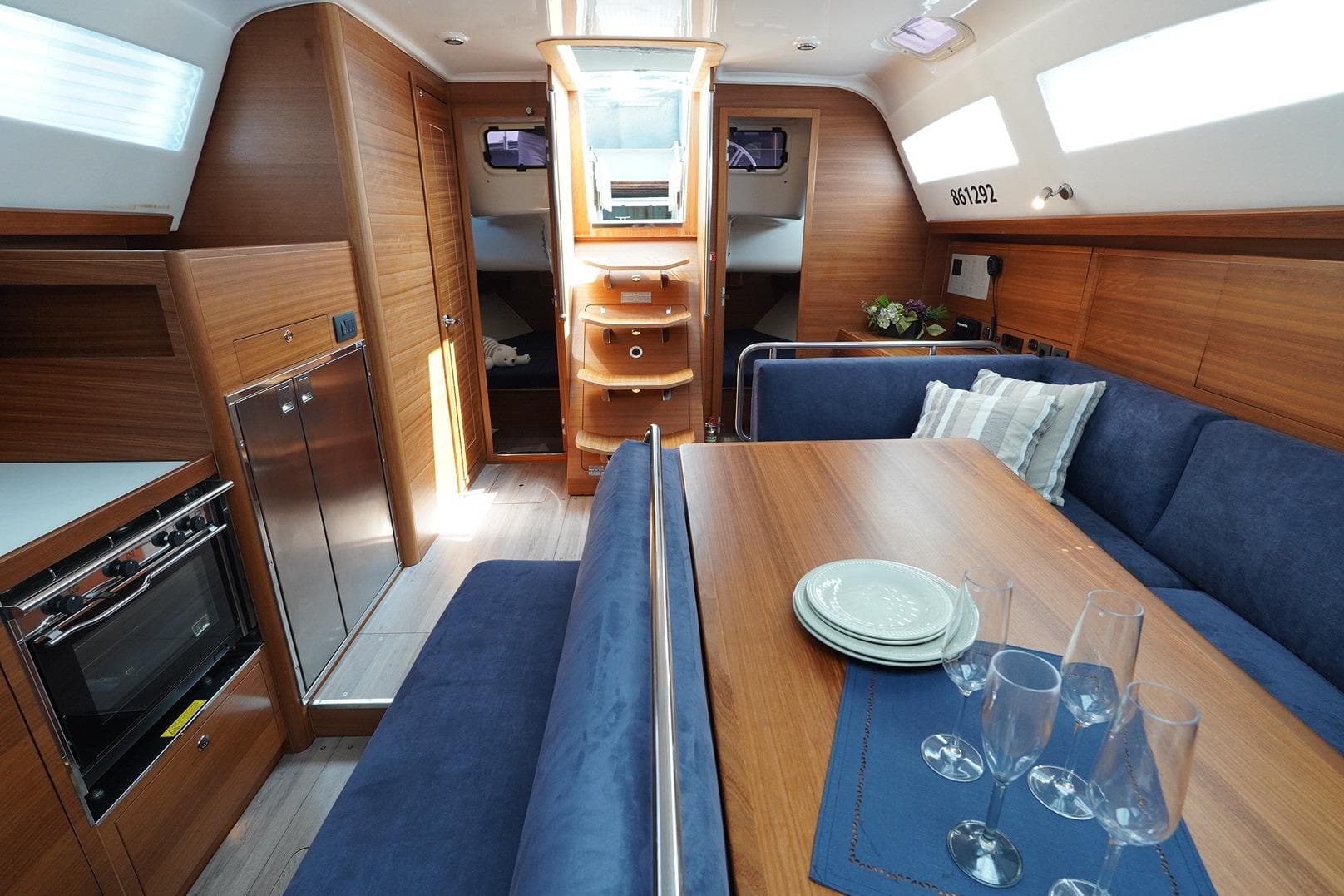 Interior of 2022 Elan IMPRESSION45.1 yacht with wood finish and blue seating.