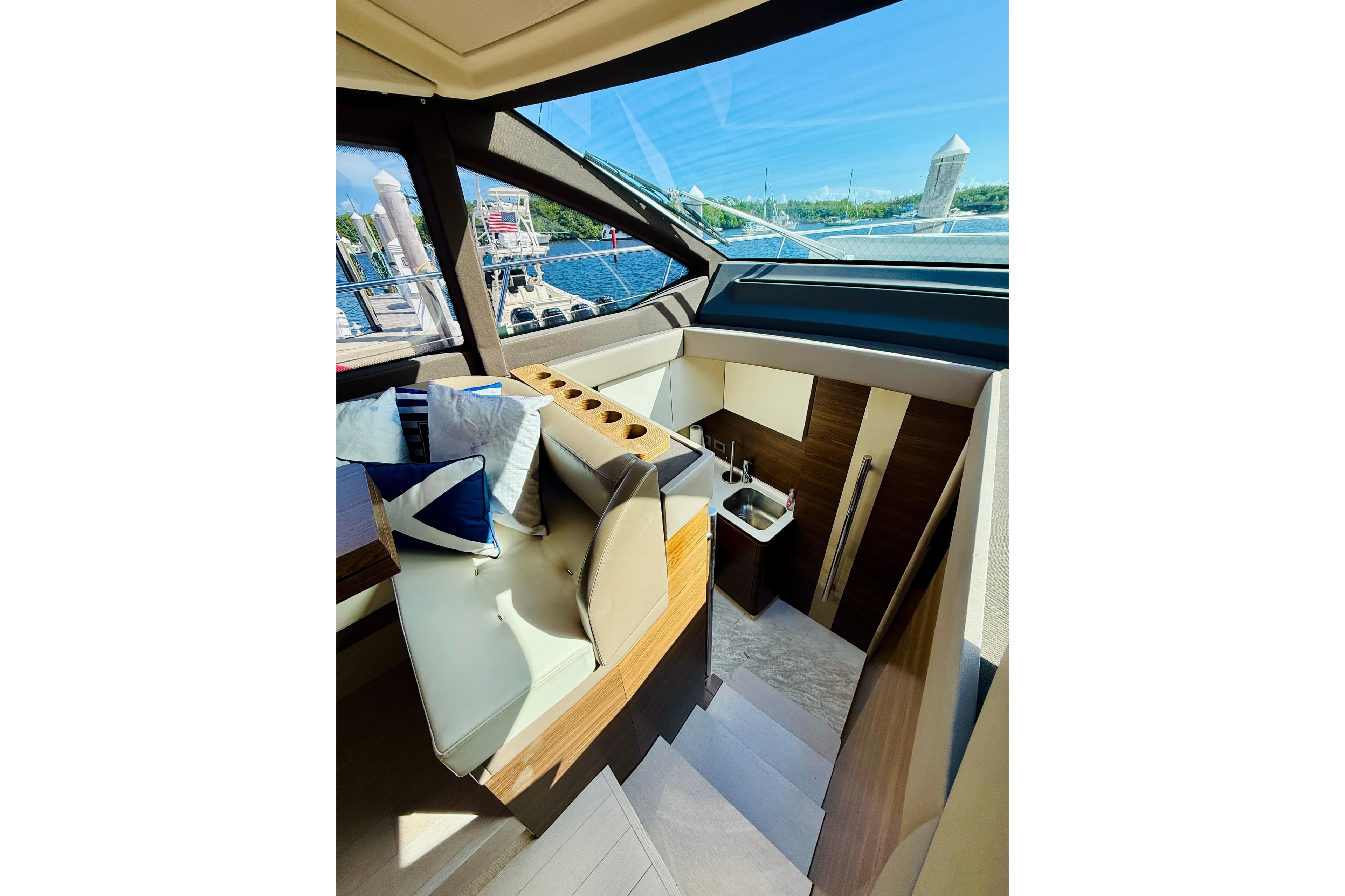 Interior of 2015 Azimut 50 yacht, featuring seating and a compact kitchenette.