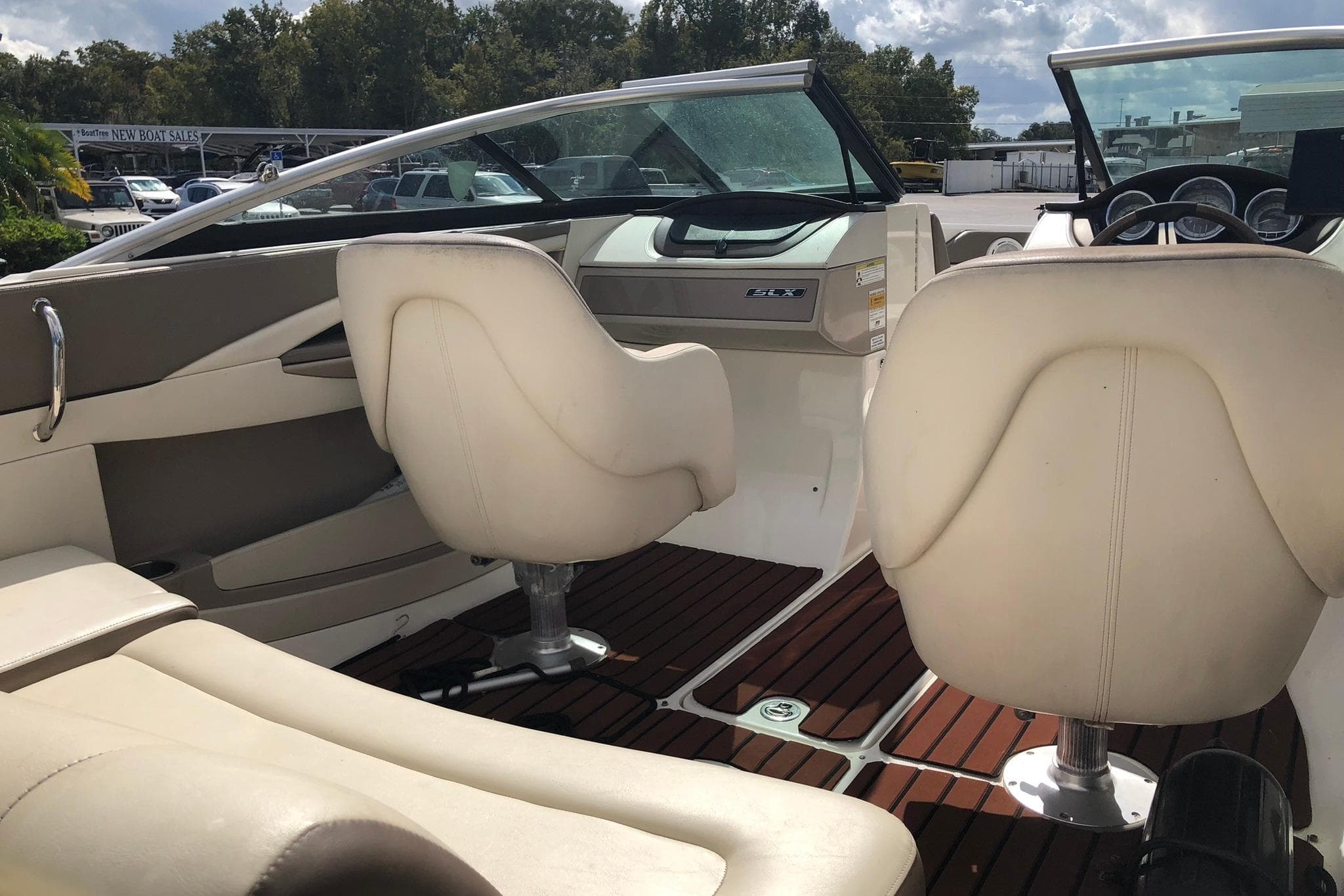 Interior of a 2012 Sea Ray 210 SLX boat with beige seating and wood flooring.