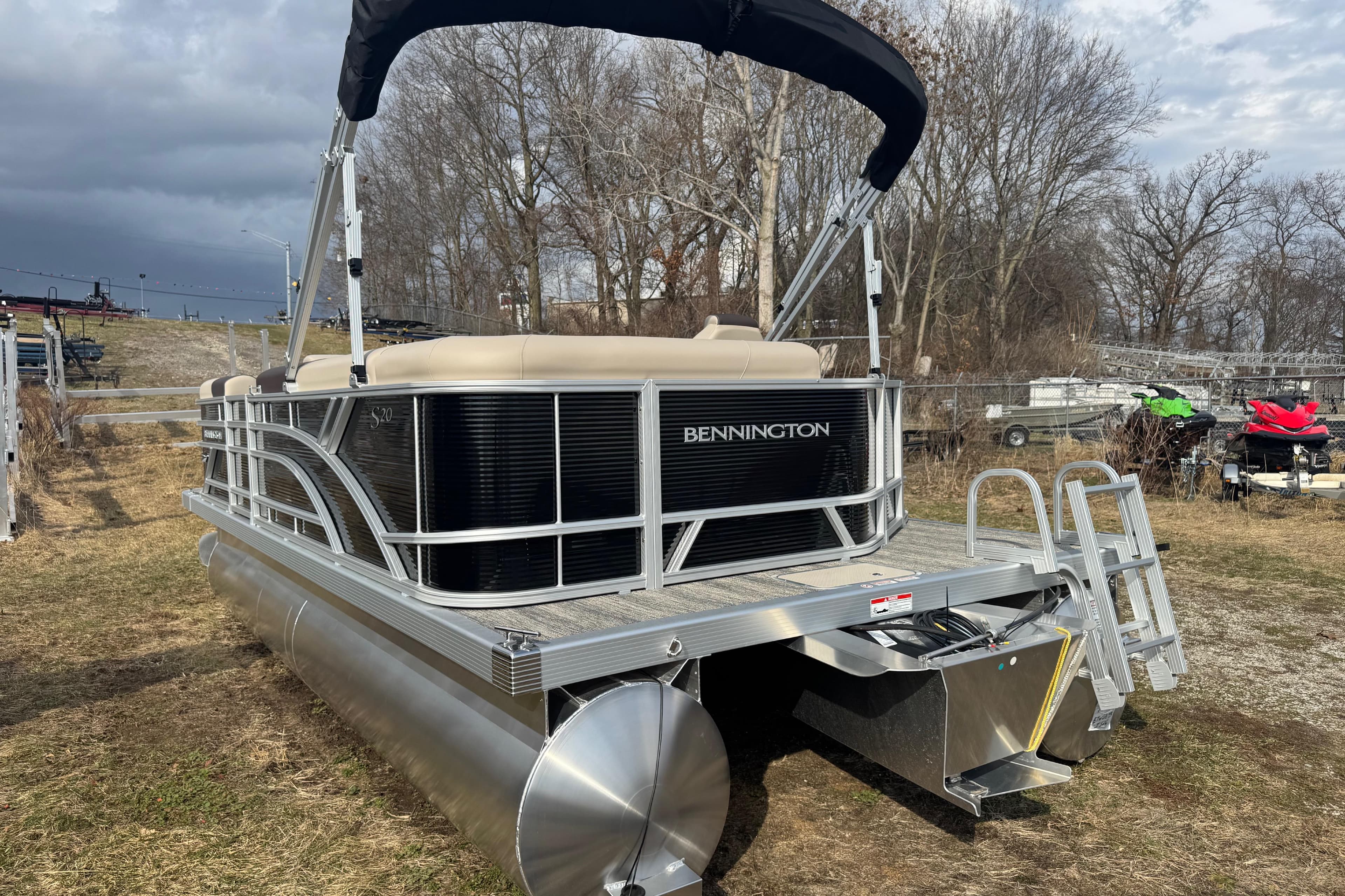 2026 Bennington 20SL pontoon boat with canopy, parked on grassy area.