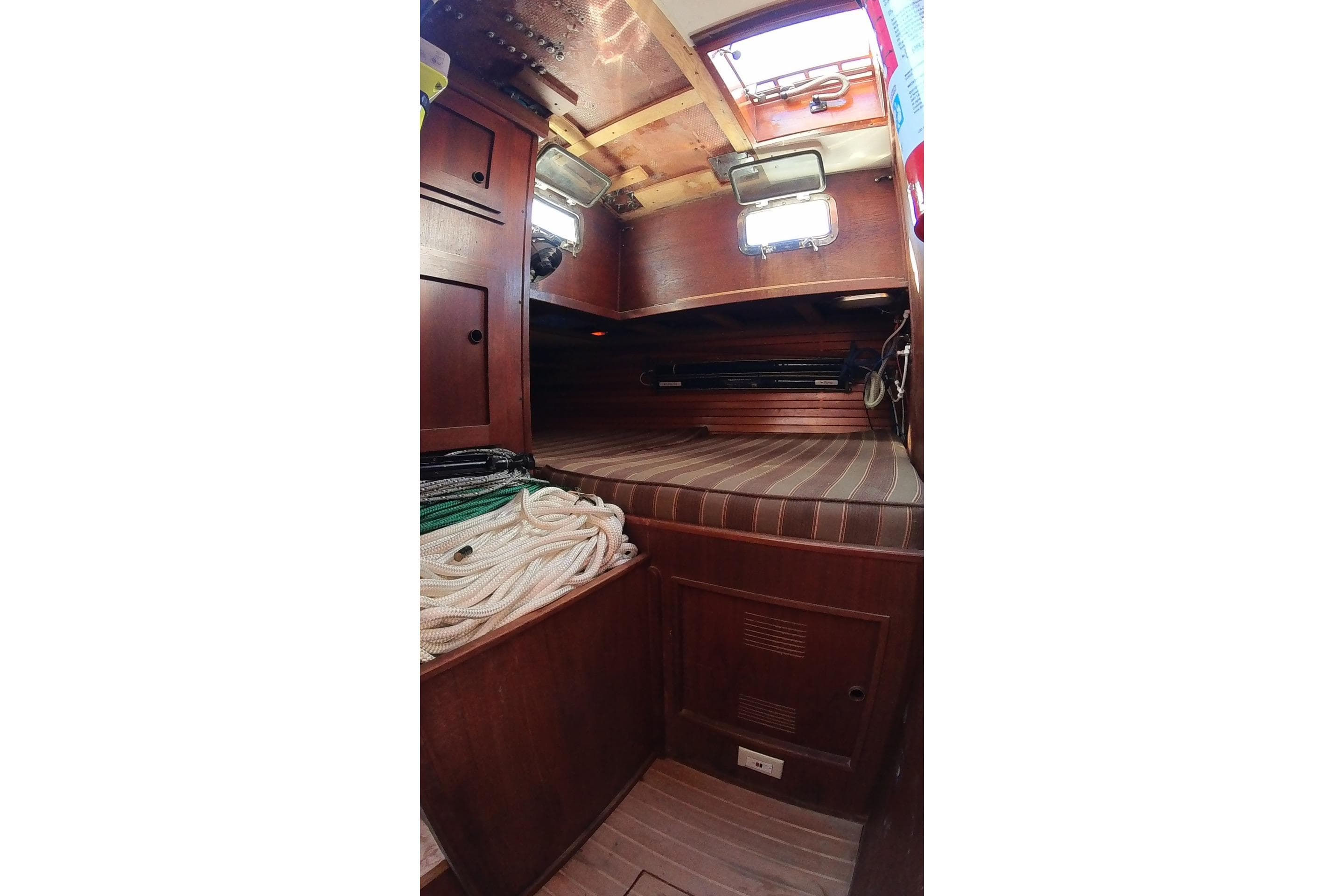 1979 Valiant 40 sailboat interior with wooden cabinetry and striped bedding.