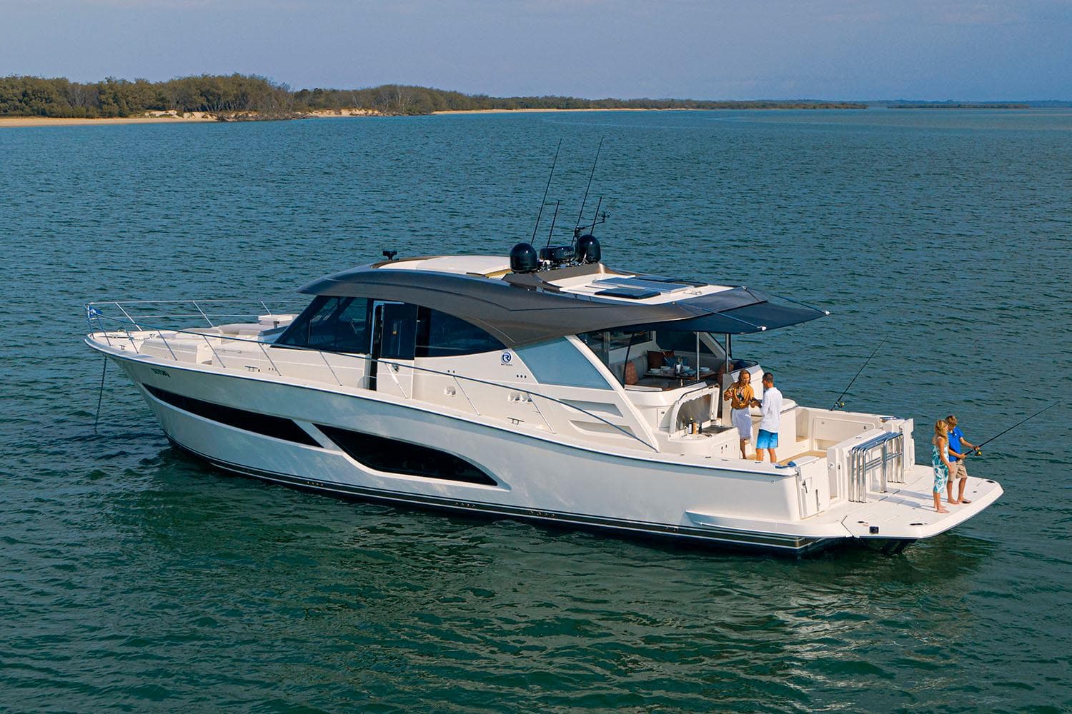 Manufacturer Provided Image: 2025 Riviera 585 SUV yacht cruising on serene waters with people on deck.