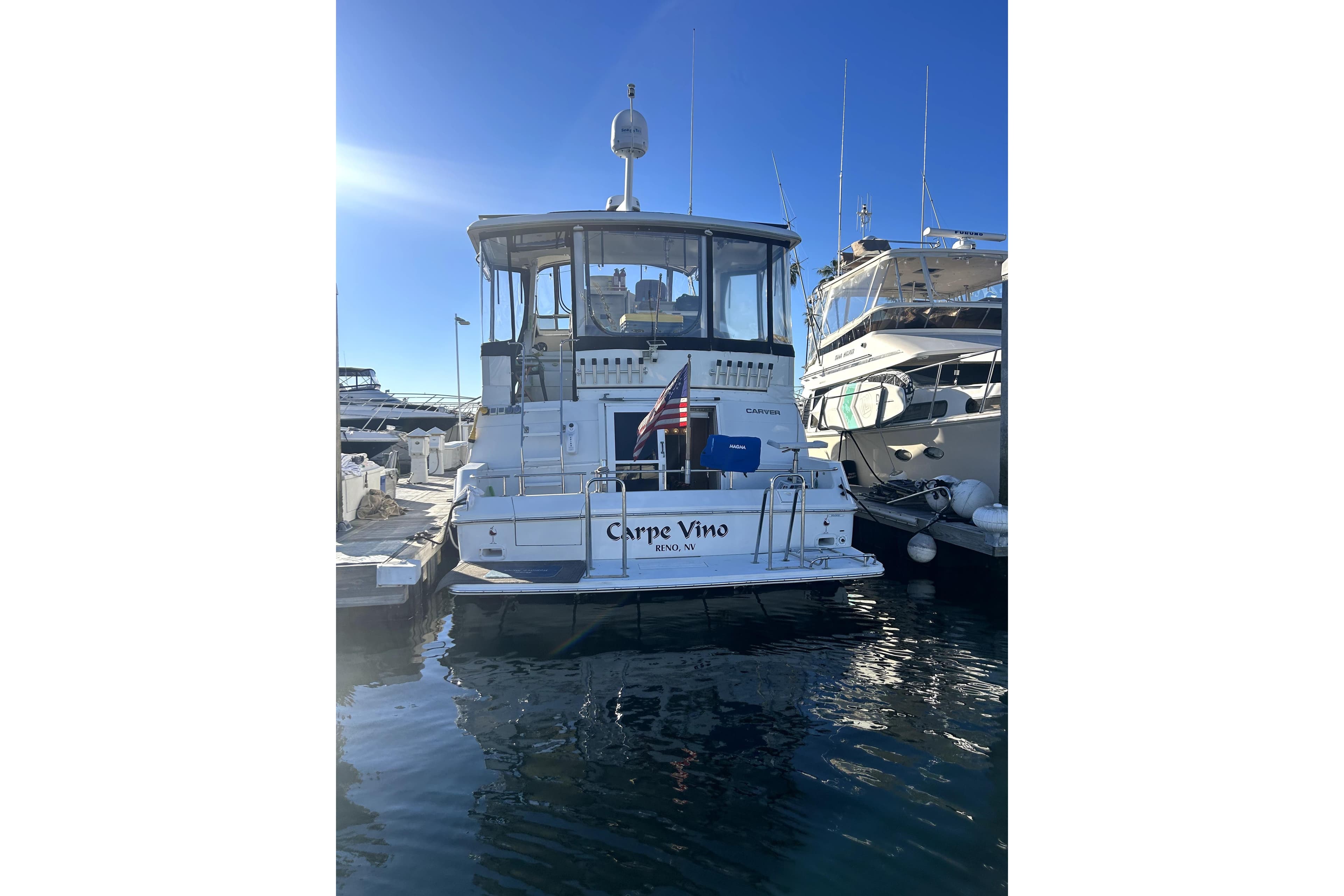 1997 Carver 430 Cockpit Motor Yacht docked at marina, sunny day, rear view.
