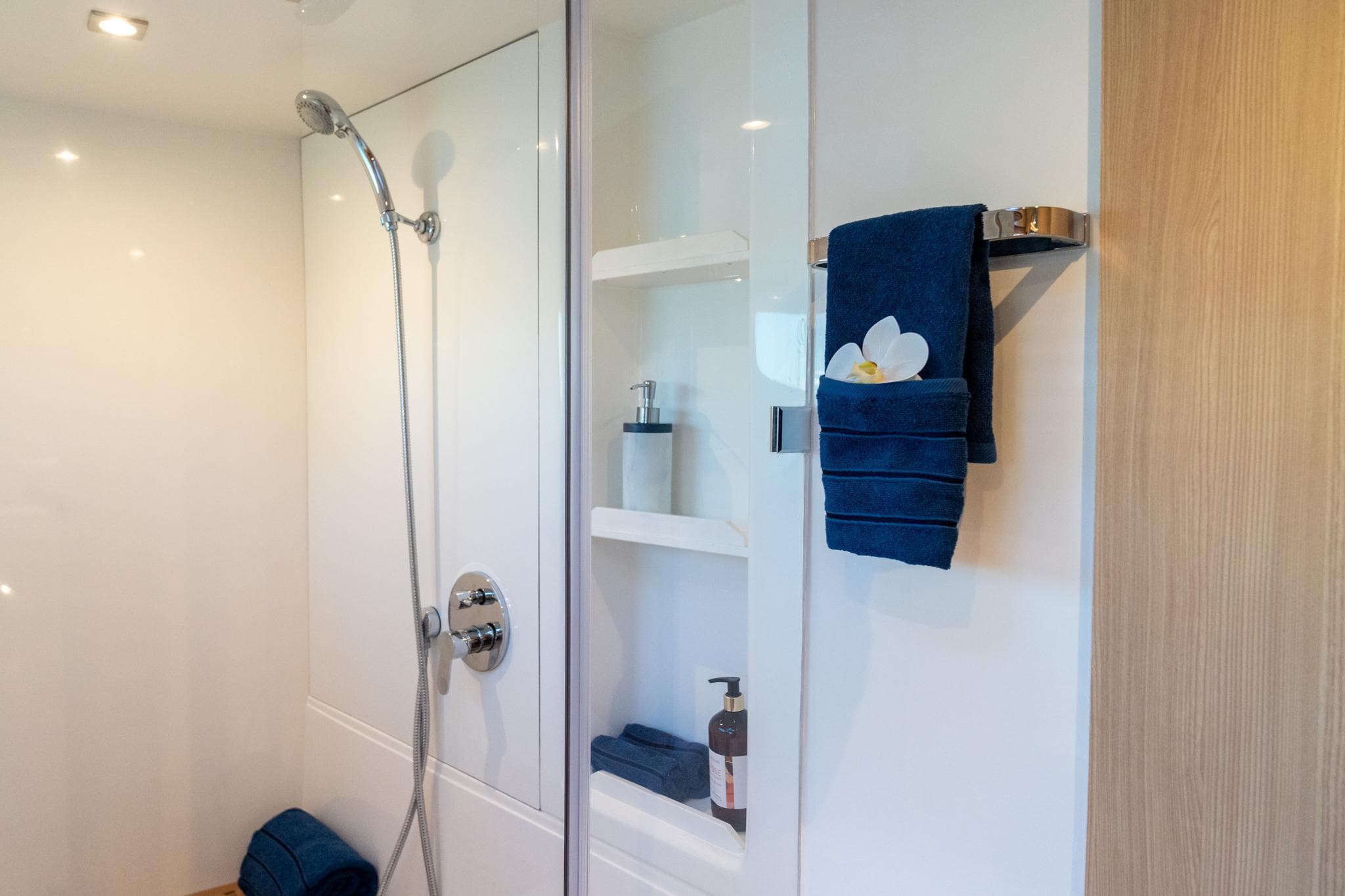 Modern bathroom in 2023 Aquila 42 Yacht with sleek shower and elegant shelving.
