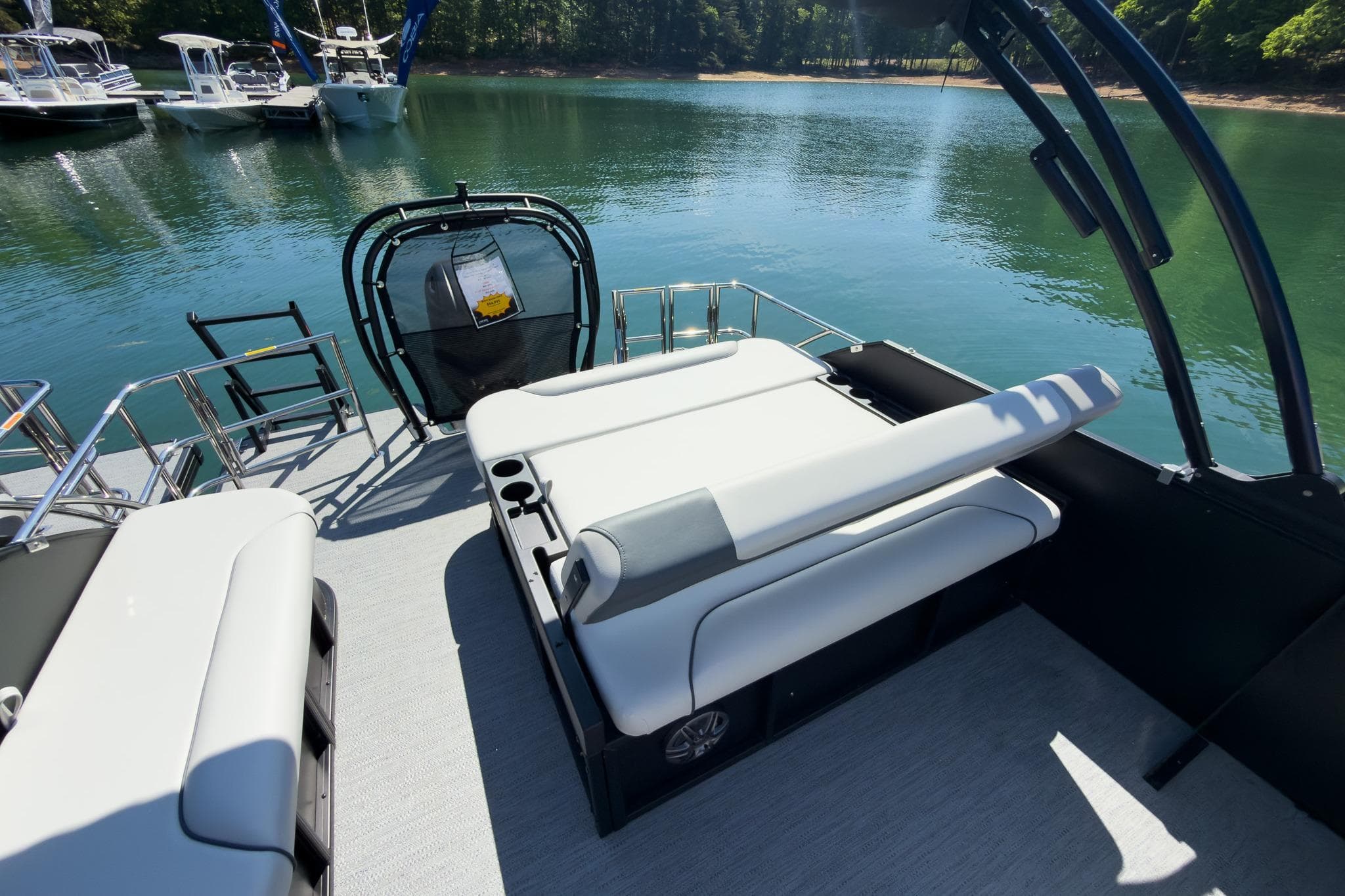 2026 Godfrey Sweetwater 22' Tritoon with flip lounge, docked on serene lake.