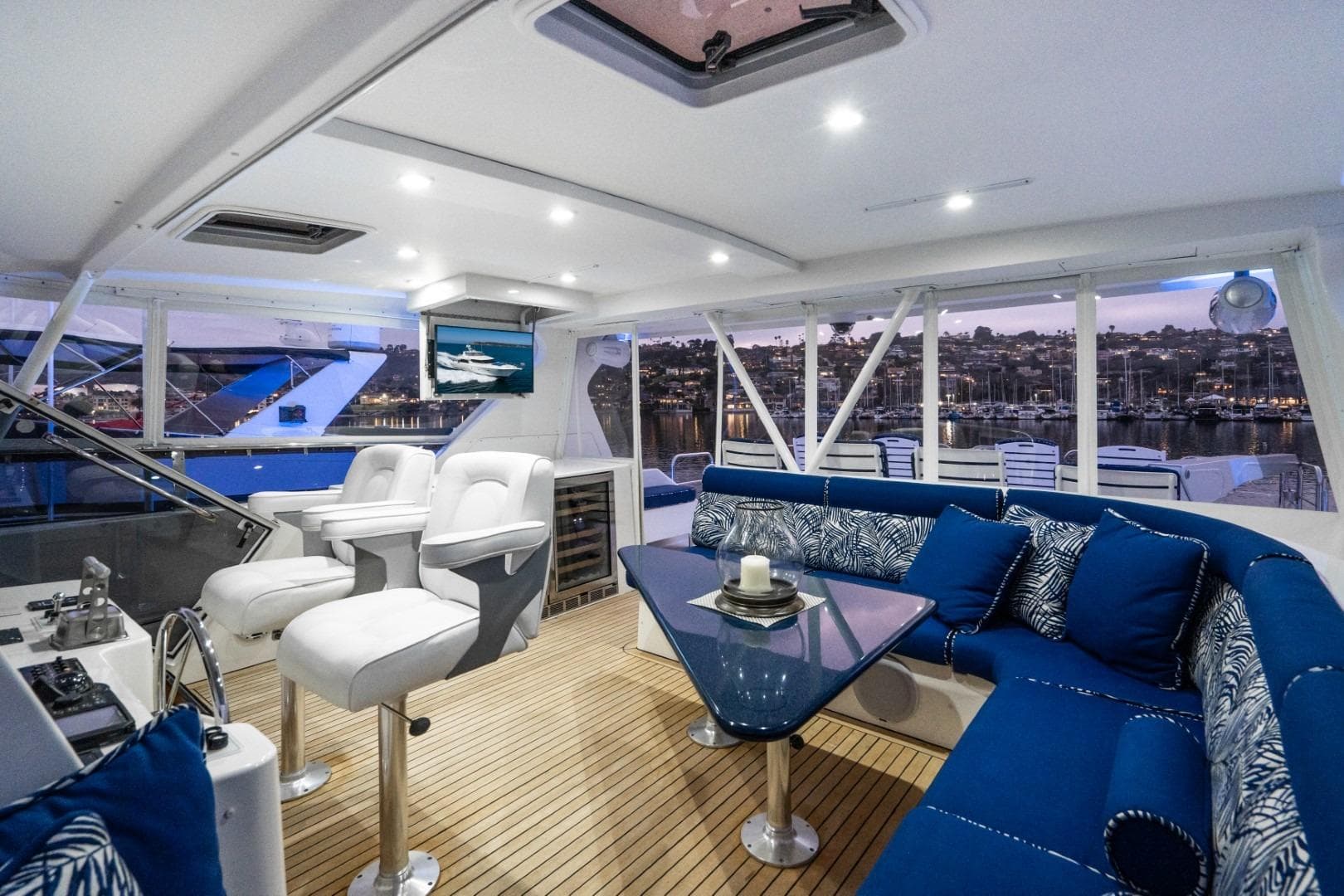 Luxurious 2001 West Bay SonShip Pilothouse interior with plush seating and scenic marina view.