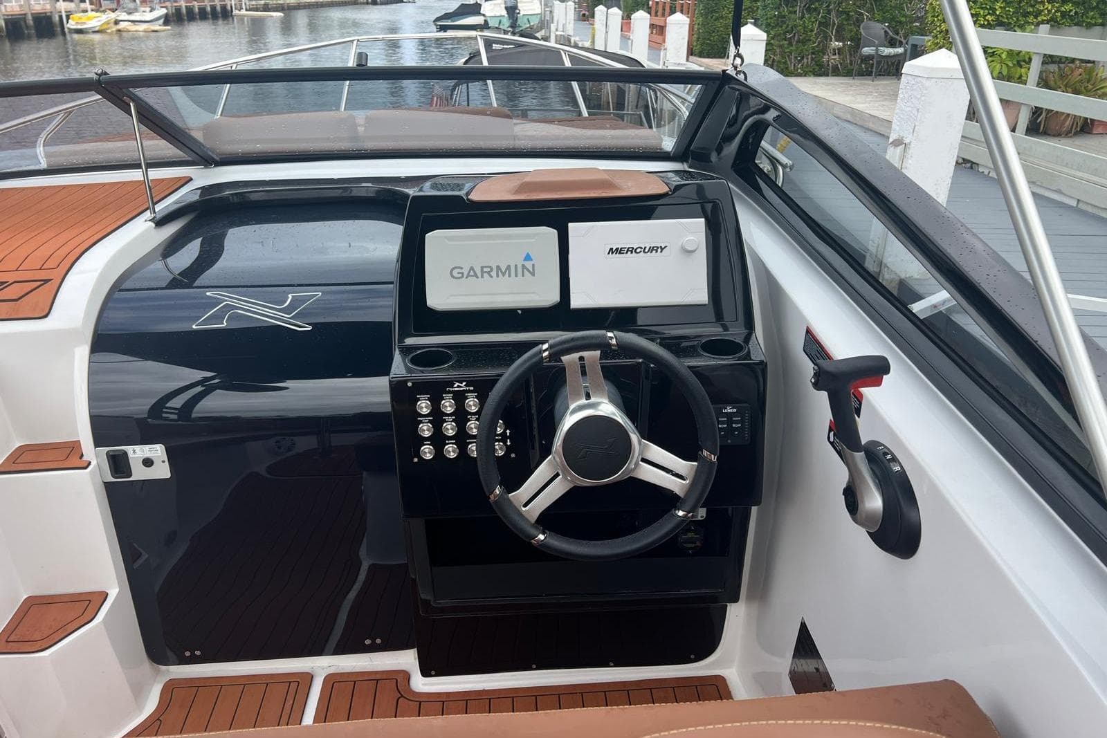 2024 NX Boats NX270 dashboard with Garmin and Mercury displays, sleek steering wheel, and modern controls.